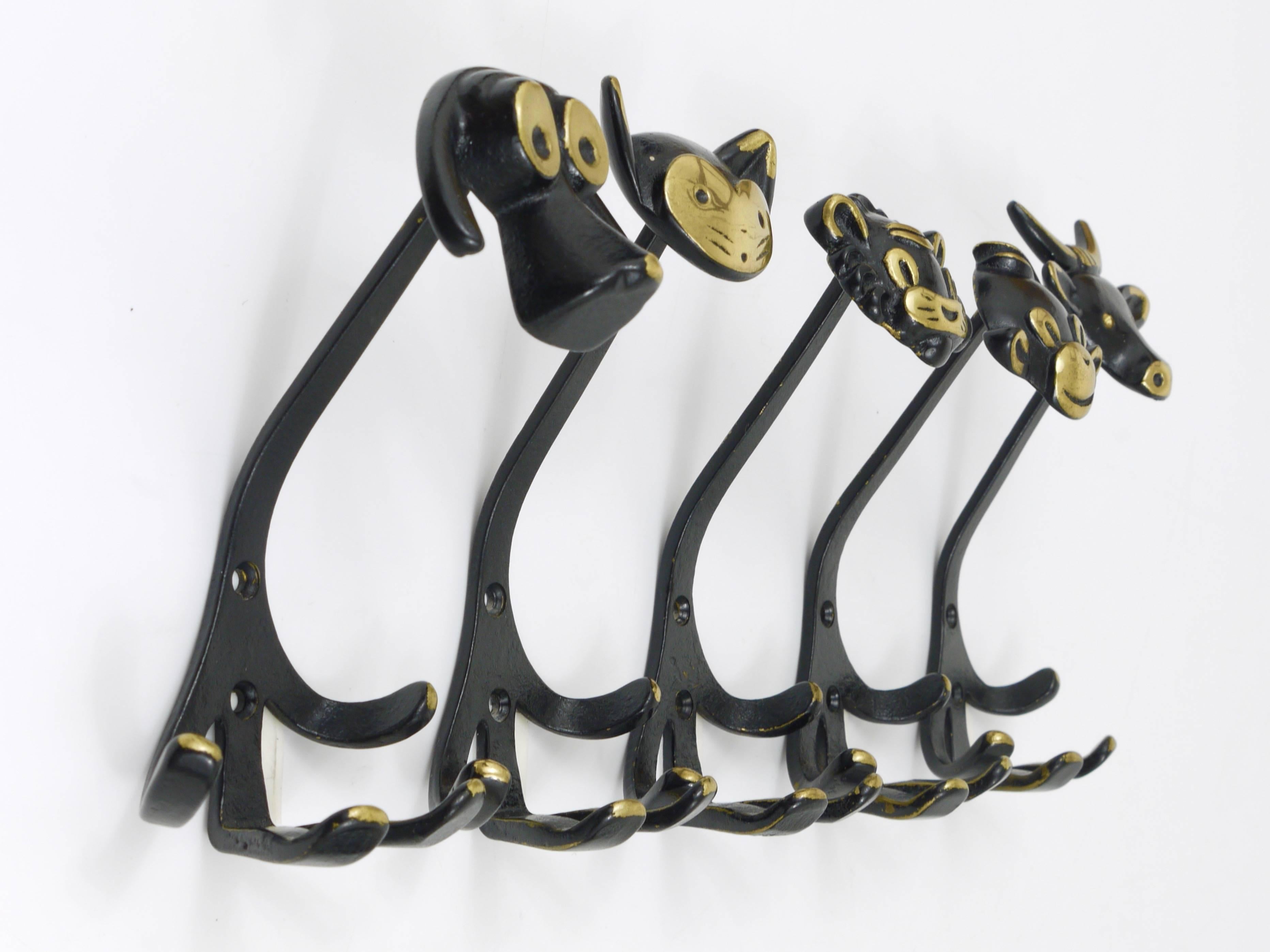 A set of five Austrian modernist brass wall coat hooks, displaying a dog, a cow, a lion, a cat and a monkey. A very humorous design by Walter Bosse, executed by Hertha Baller Austria in the 1950s. Made of black finished brass. In excellent