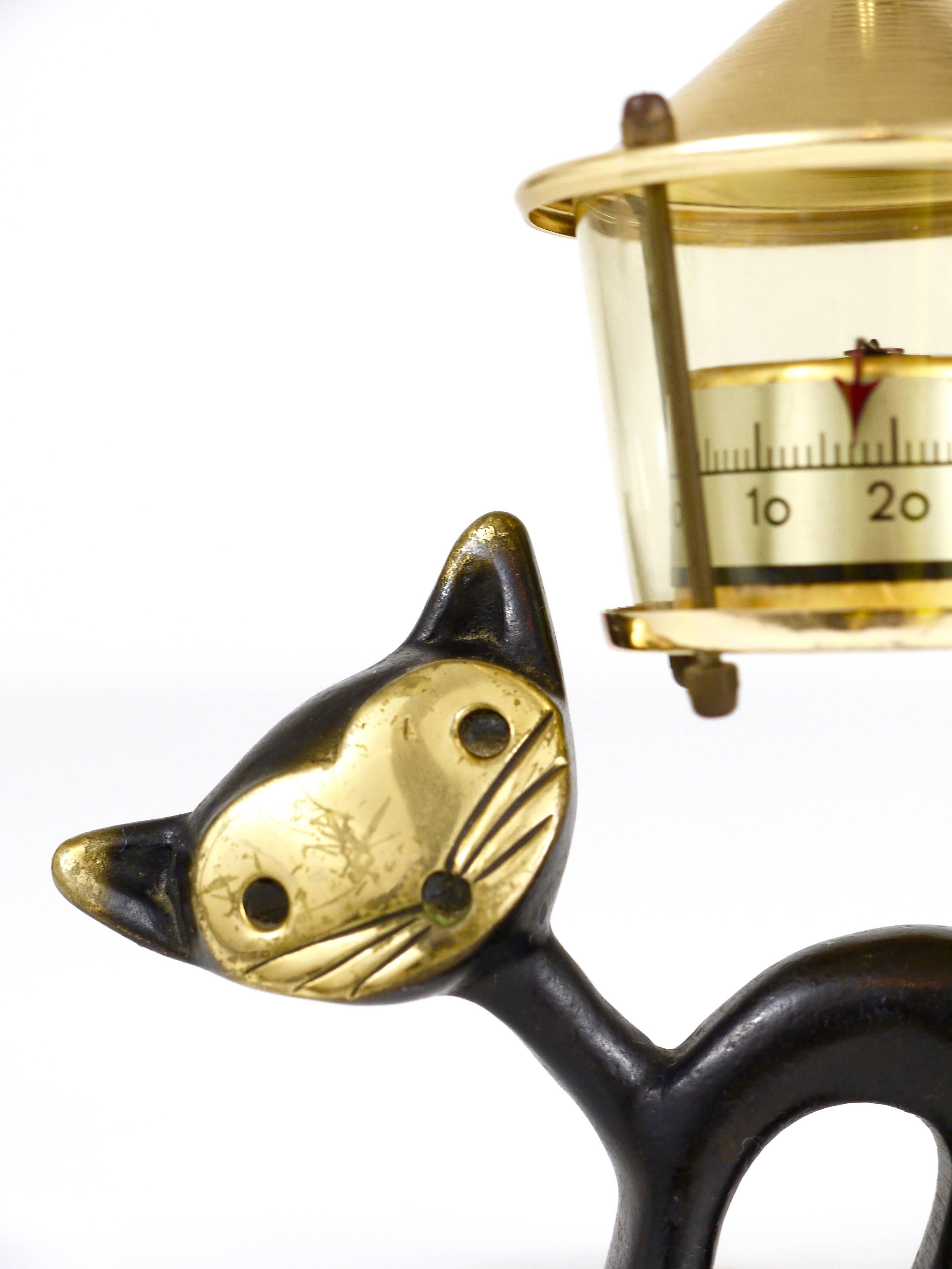 Charmant thermomètre de bureau autrichien moderne du milieu du siècle, composé d'une jolie figurine de chat et d'un thermomètre en forme de lanterne. Un design humoristique de Walter Bosse, exécuté par Hertha Baller Austria dans les années 1950. En