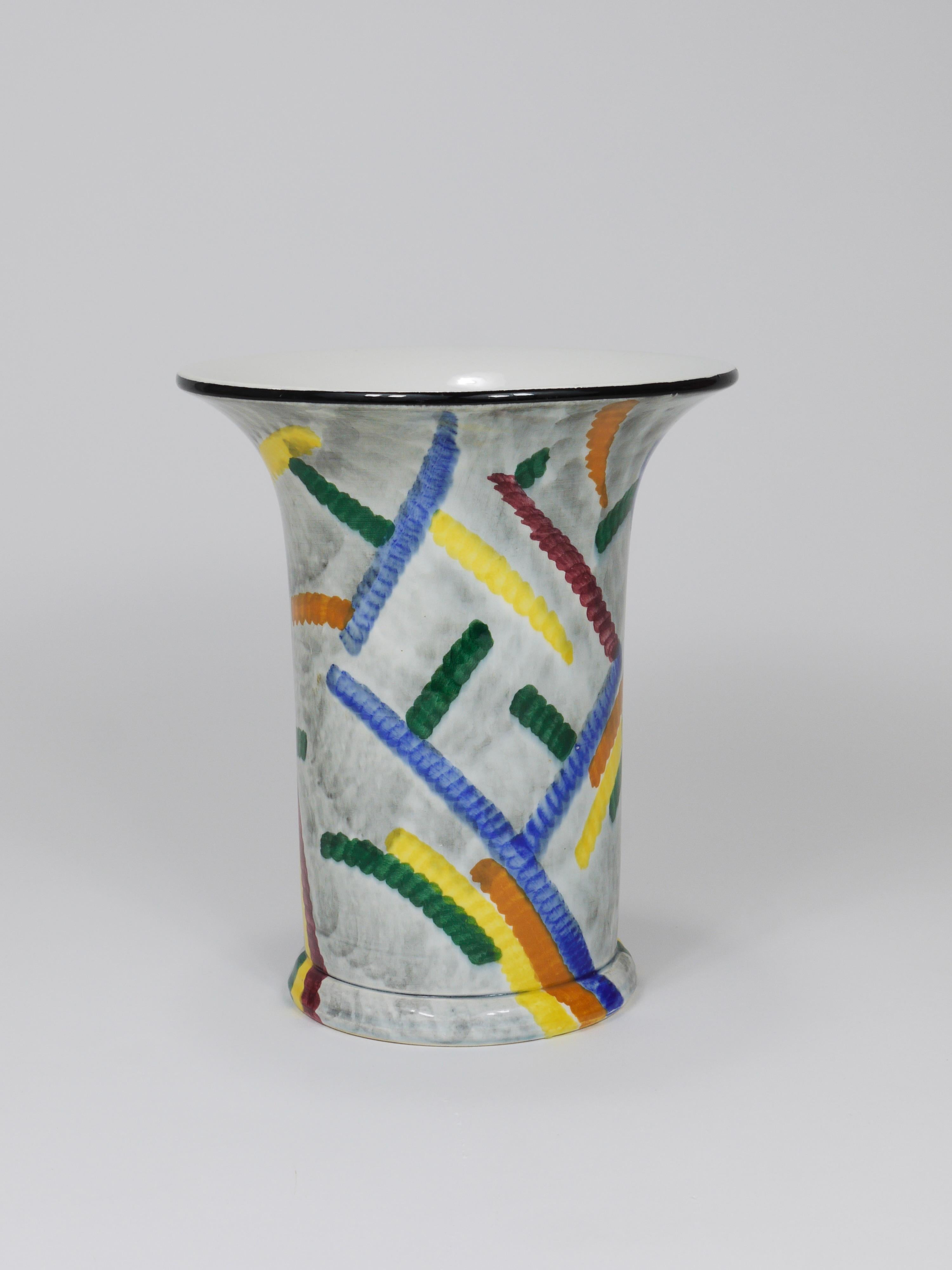 A colorful and charming Majolica pottery vase from the German modernist Bauhaus era, designed in the late 1920s by Eva Zeisel for the Schramberg Majolika Fabrik (SMF) in Germany. Handmade from ceramic and hand-painted, the vase features a geometric,