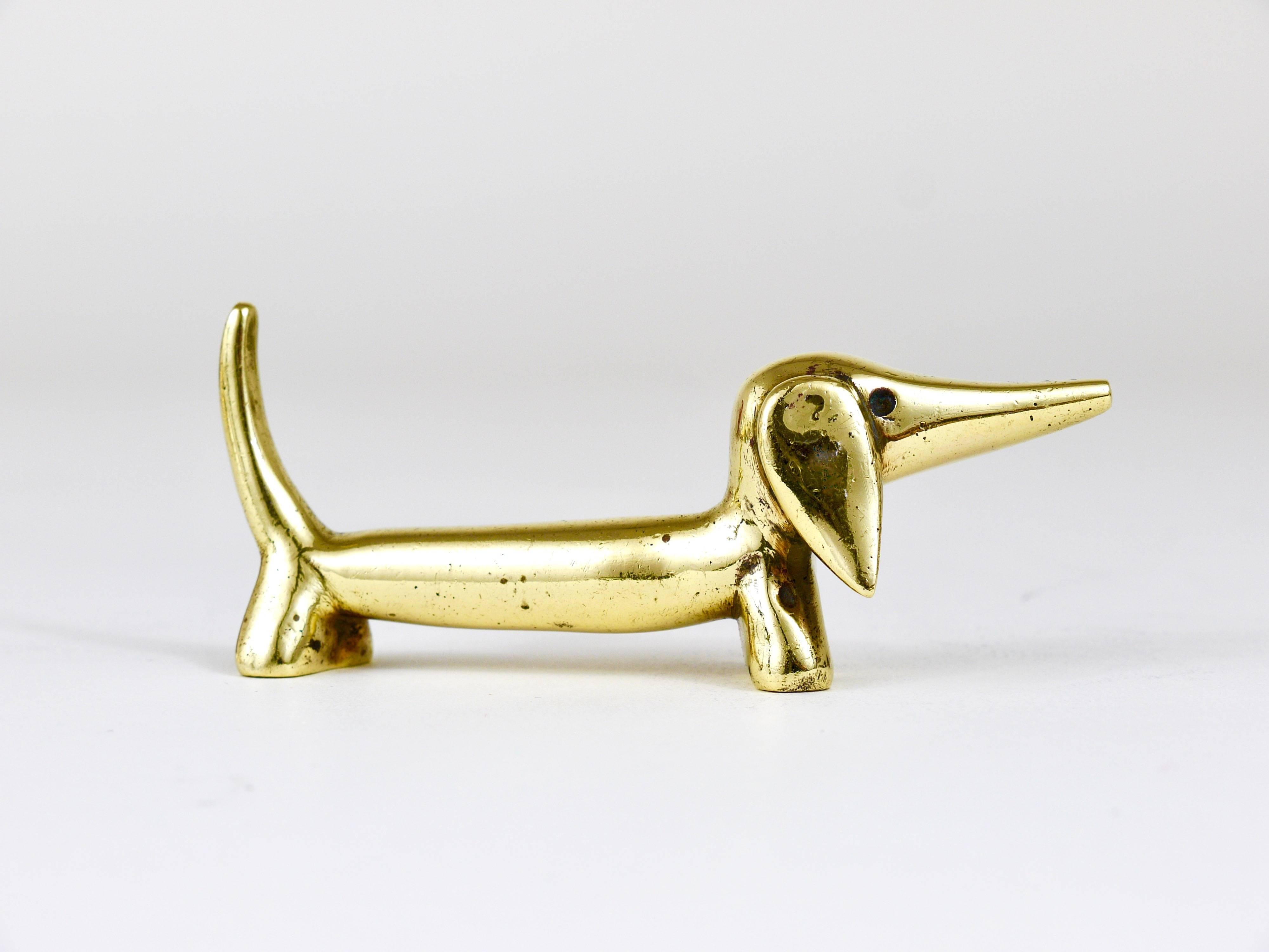 A lovely sausage dog sculpture made of brass from the 1950s. Designed by Walter Bosse, executed by Hertha Baller. In good condition with charming patina.