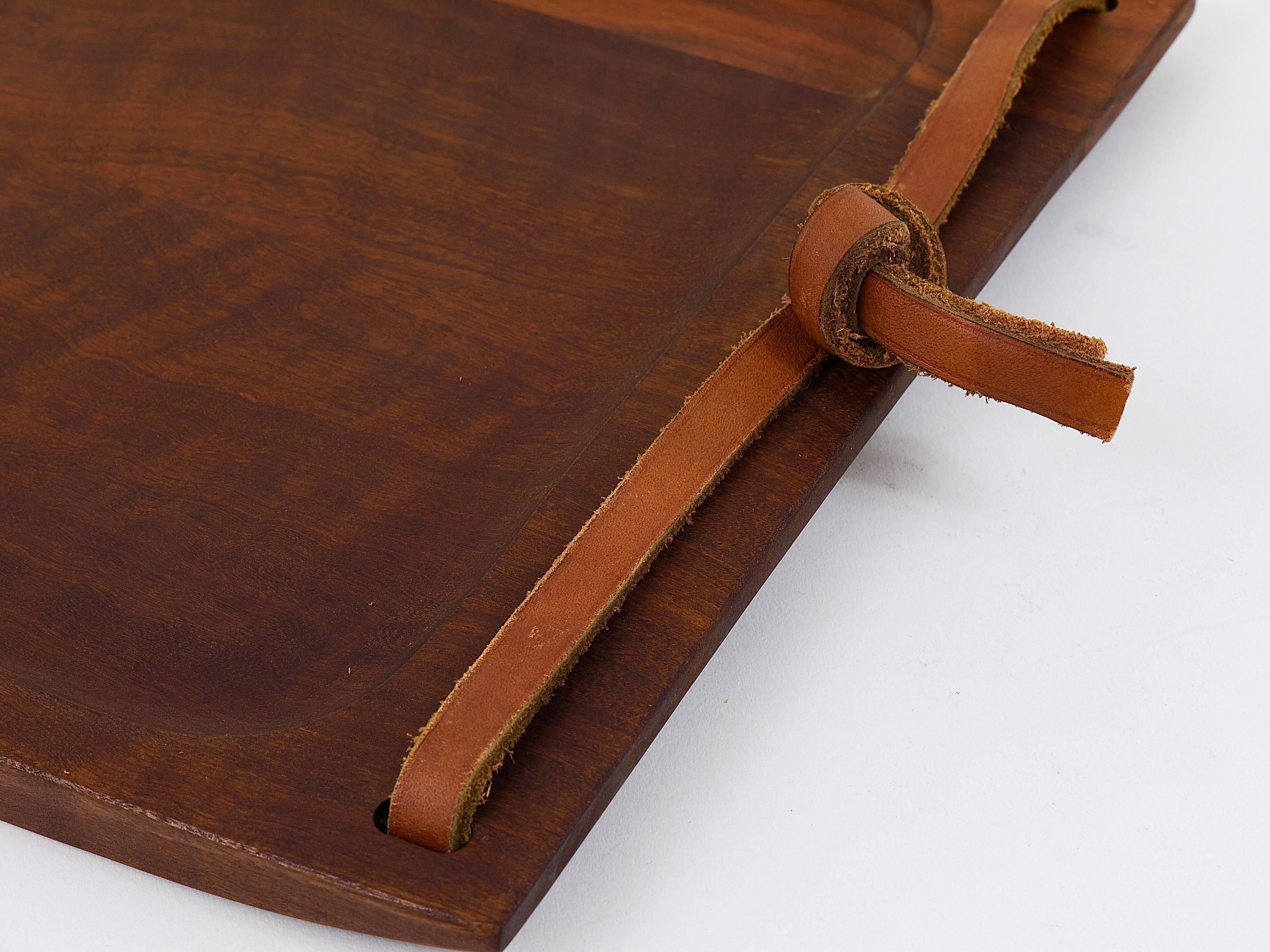 A very large and also rare modernist serving tray from the 1950s, designed and executed by Carl Aubock, Austria. Made of walnut and brown leather. In excellent condition.