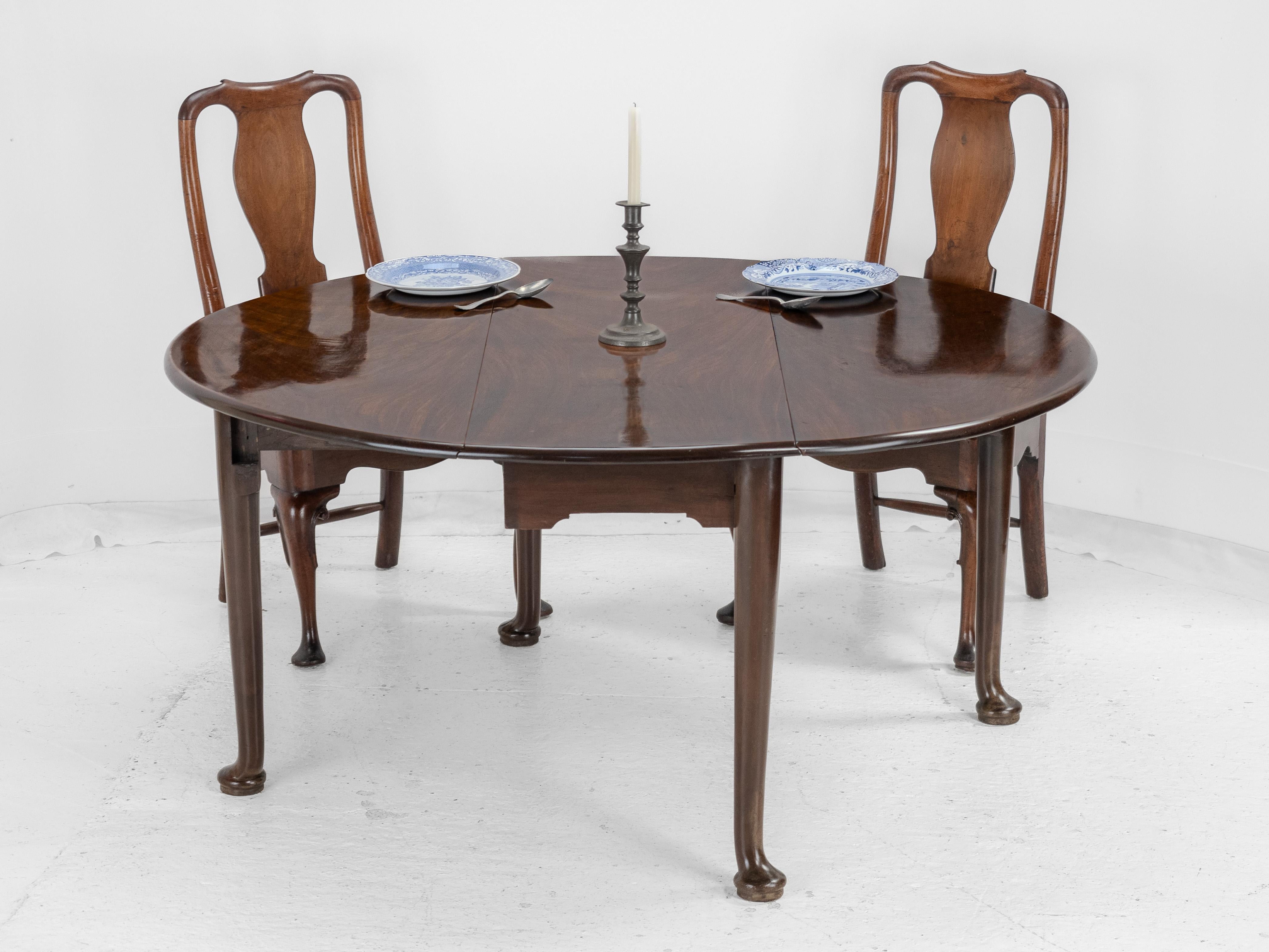 A George II period, Cuban mahogany oval dining table, circa 1730. Featuring a thick, solid and very well figured, mahogany top in oval form. Constructed from 3 leaves of the earliest, dense, highest quality, heavy Cuban mahogany. The drop leaves are