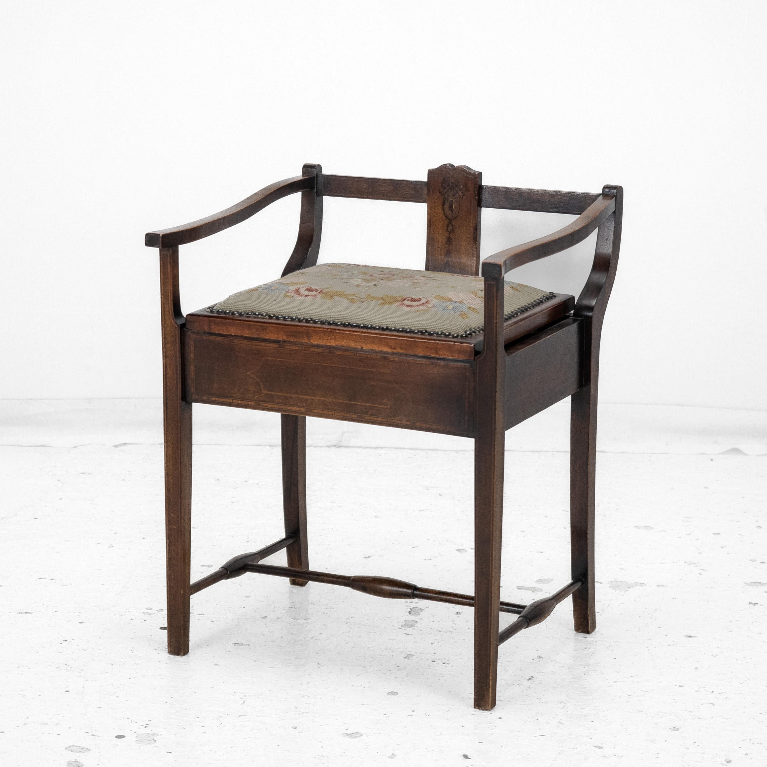 An early 20th century, Edwardian period mahogany framed piano stool. The hinged tapestry seat lid reveals a small storage compartment. The frame in inlaid with bowwood stringing.

Dimensions:

This piano stool measures approximately 61 cm (24