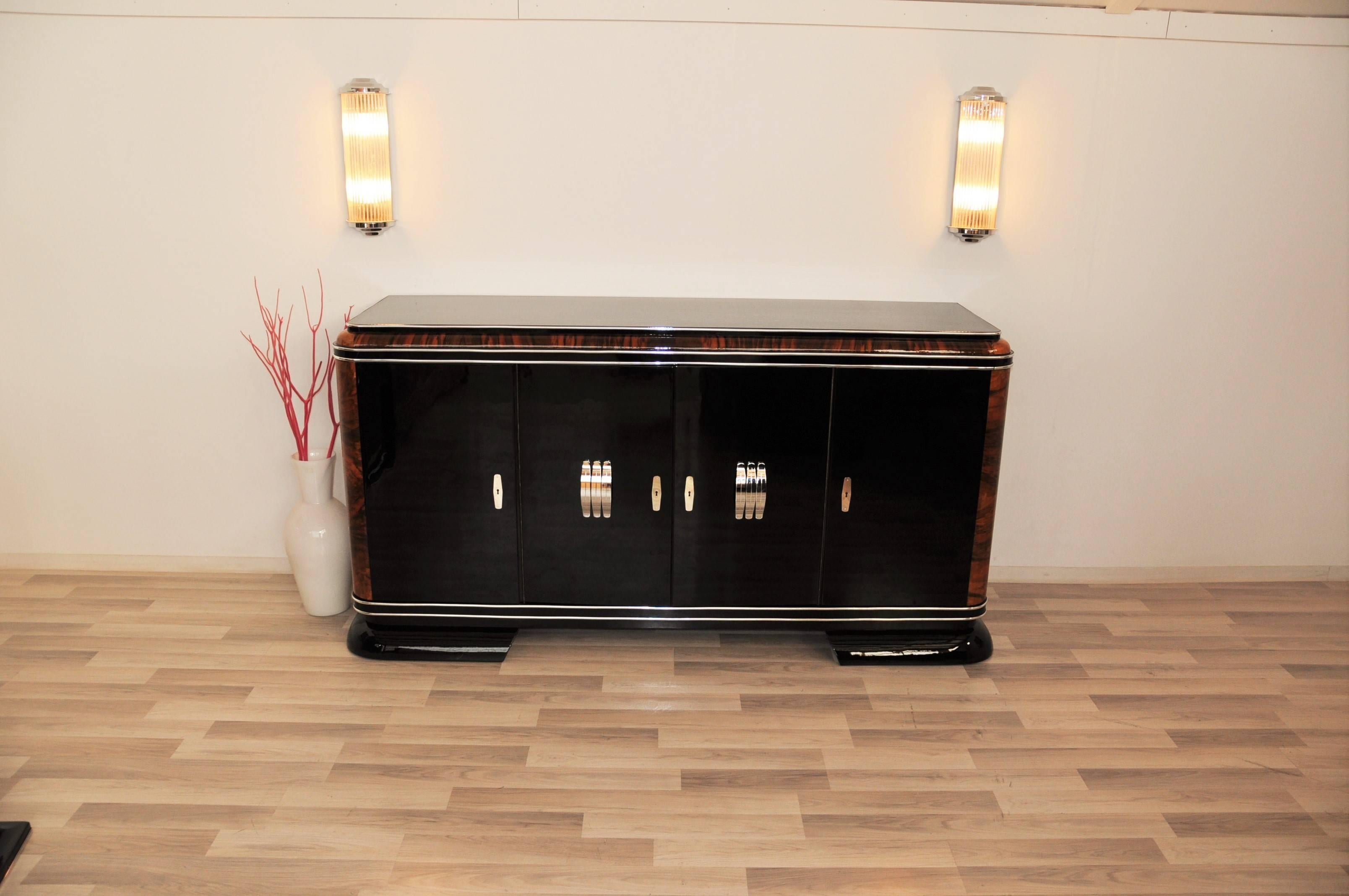 Wonderful piano lacquer sideboard with mahogany details and big chrome handles. The combination of luxurious mahogany, high quality piano lacquer and big chrome handles offers a unmistakable design!

Big sideboard / buffet with fine