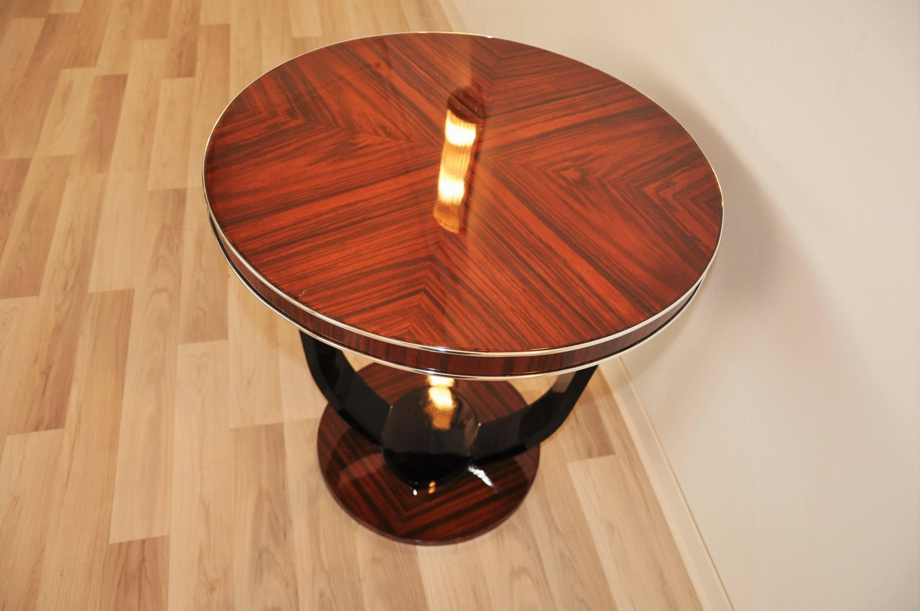 Luxurious Art Deco side table made of wonderful santos palisander wood. Completely restored single piece with hand-polished clear lacquer.

 Two part foot - refined with piano lacquer
 elegant, free floating design
 narrow chrome bars.

Second