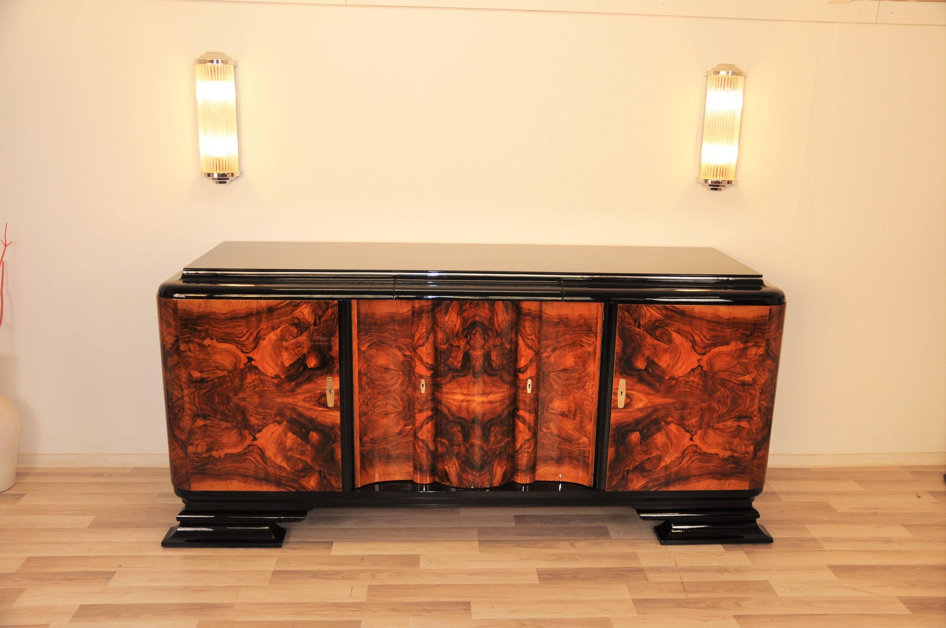 Great Art Deco sideboard or buffet with serpentine doors. Rare single piece with wonderfully carved walnut veneer and handpolished highgloss lacquer.

Ttypical Art Deco design with rounded corners and a straight forward body.
 Unique and rare