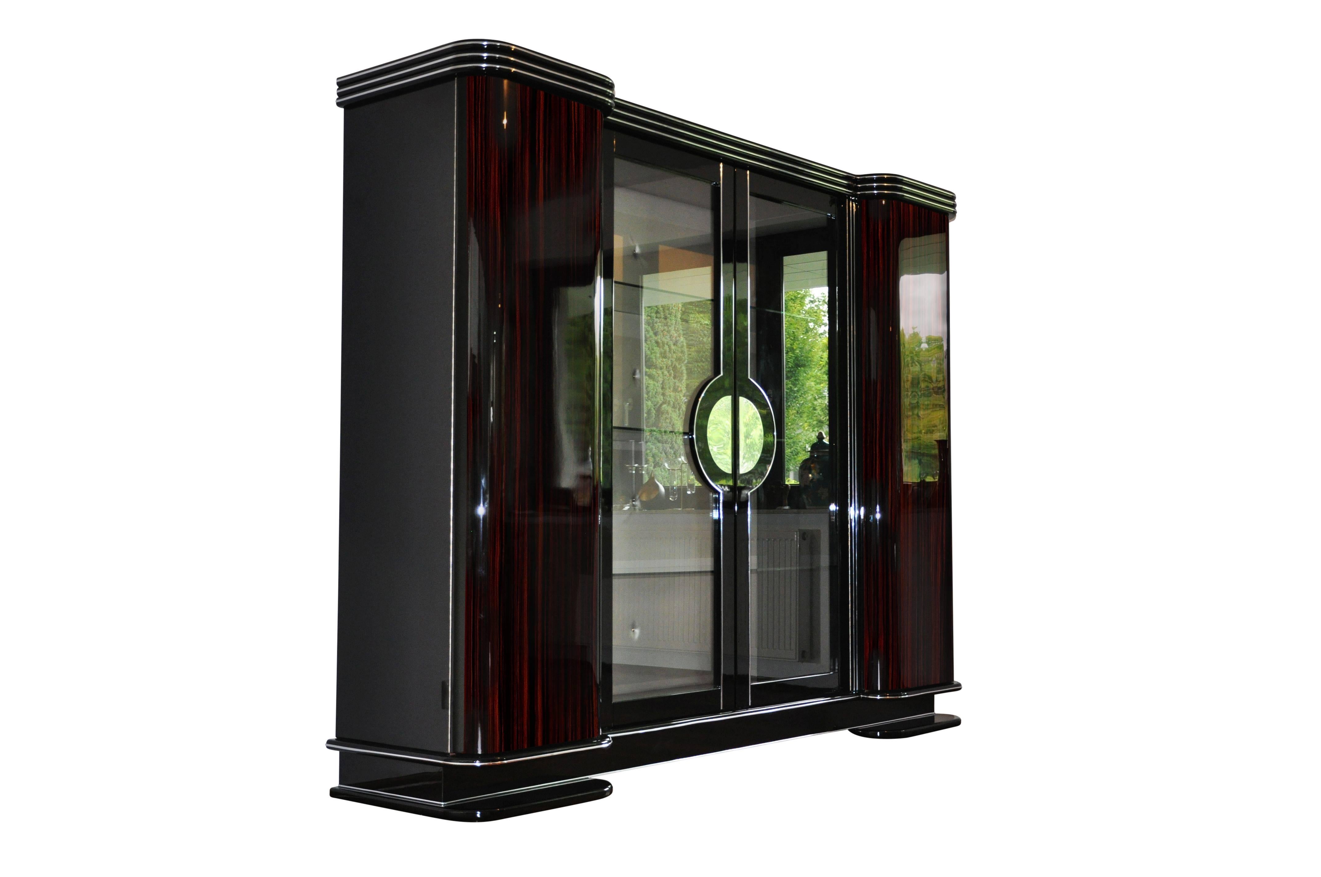 A cabinet with curved wing doors and beautiful art deco style chrome applications. In the middle you will find doors with glass panels and shleves so the cabinet can work as a vitrine for your favorite pieces. A masterpiece of Art Deco style design