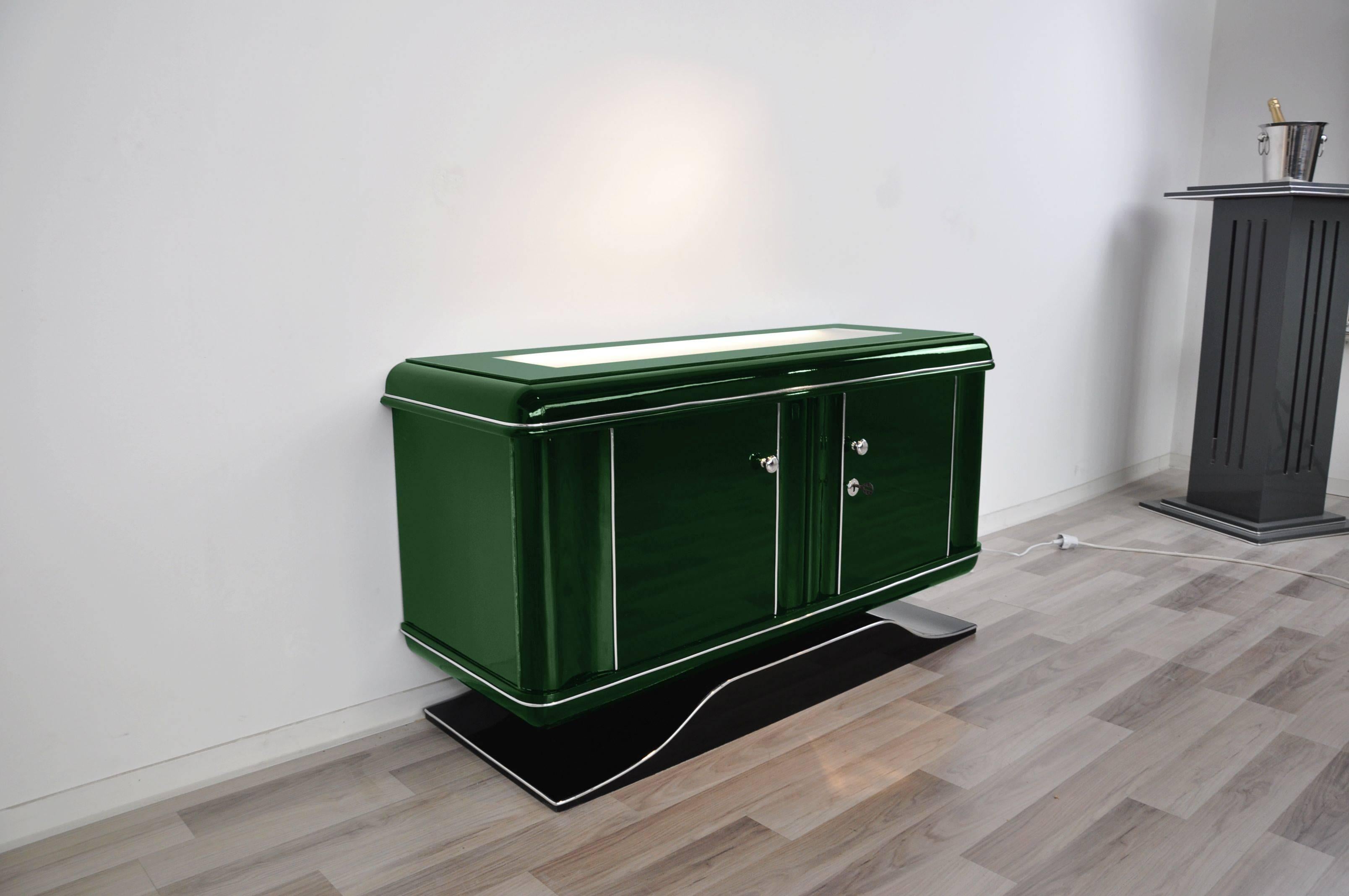 Illuminated Art Deco dresser or commode with a wonderful paintjob. This amazing piece of furniture offers a great color combination with a matte white interior and a Jaguar Racing Green exterior. The top milk glass plate is illuminated from
