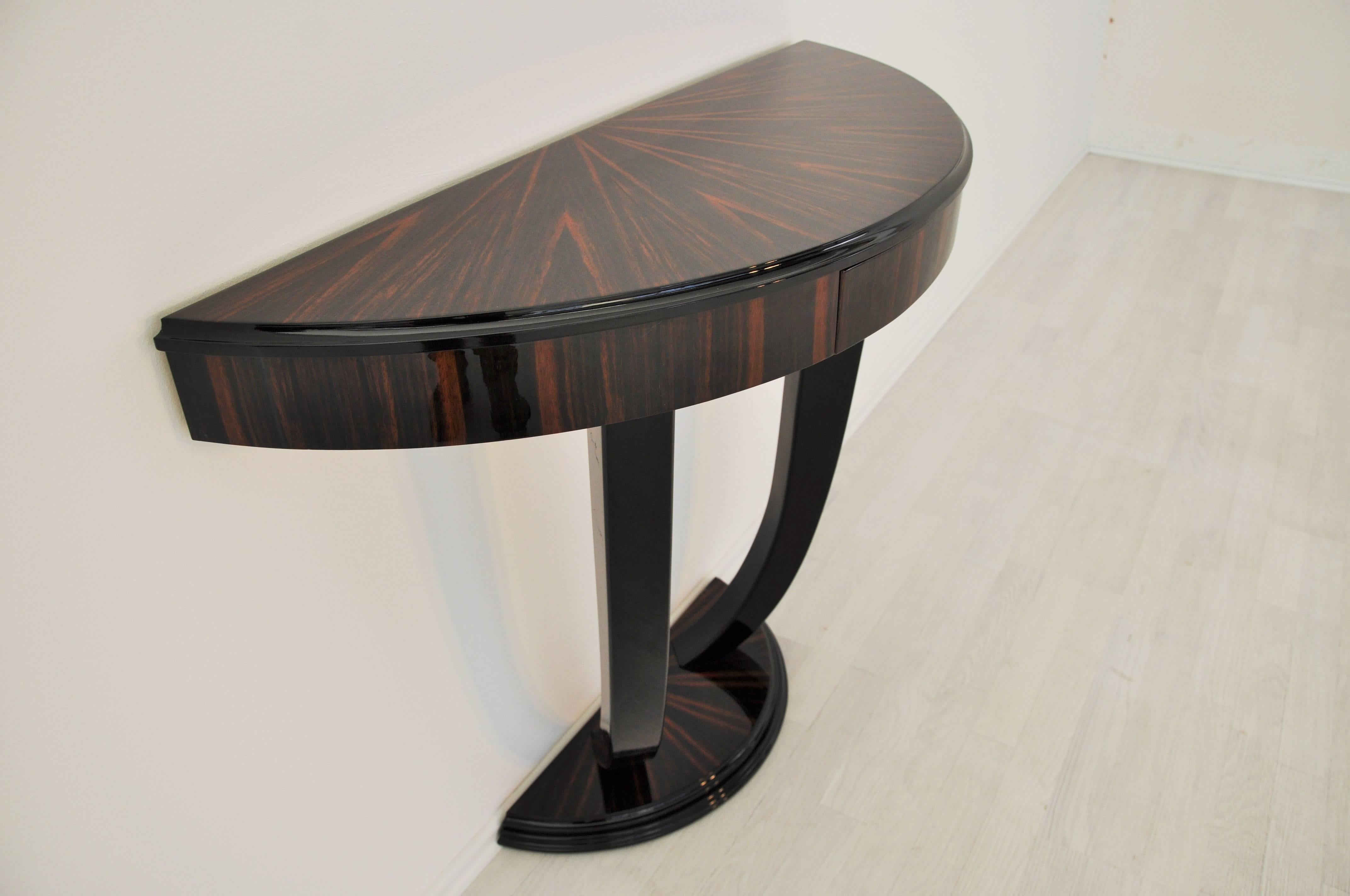 Stunning Art Deco design wall console with a wonderful Macassar veneer. Finished all around with a high gloss lacquer. The curved legs are worked with high quality piano lacquer. With a petite stair foot and fine details.