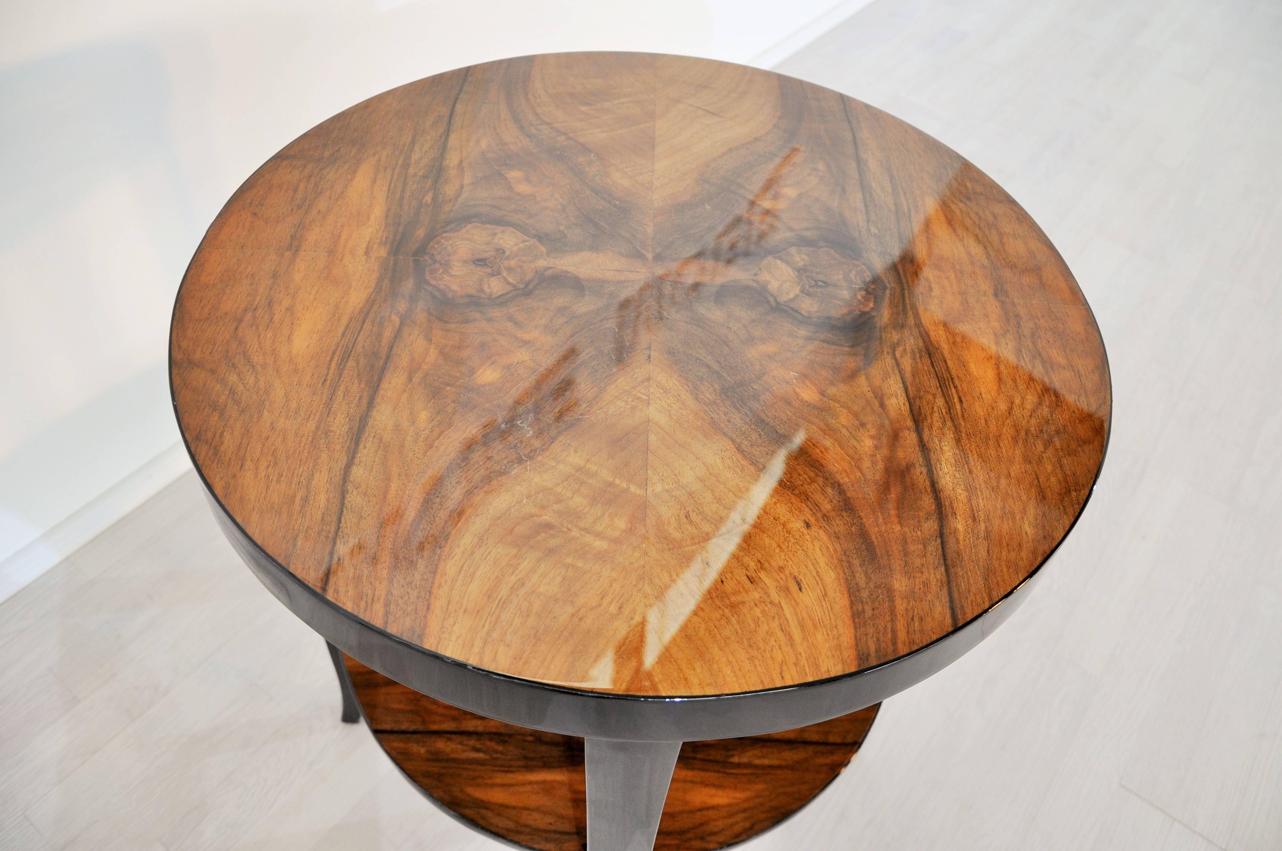 Wonderful Side table from the 1930s.

Legs with a multilayer piano lacquer
Tabletop made of walnut-wood with a stunning grain
Compact measurements, diameter of 56cm

An absolute stunning piece from a great furniture era.
We got our hands on