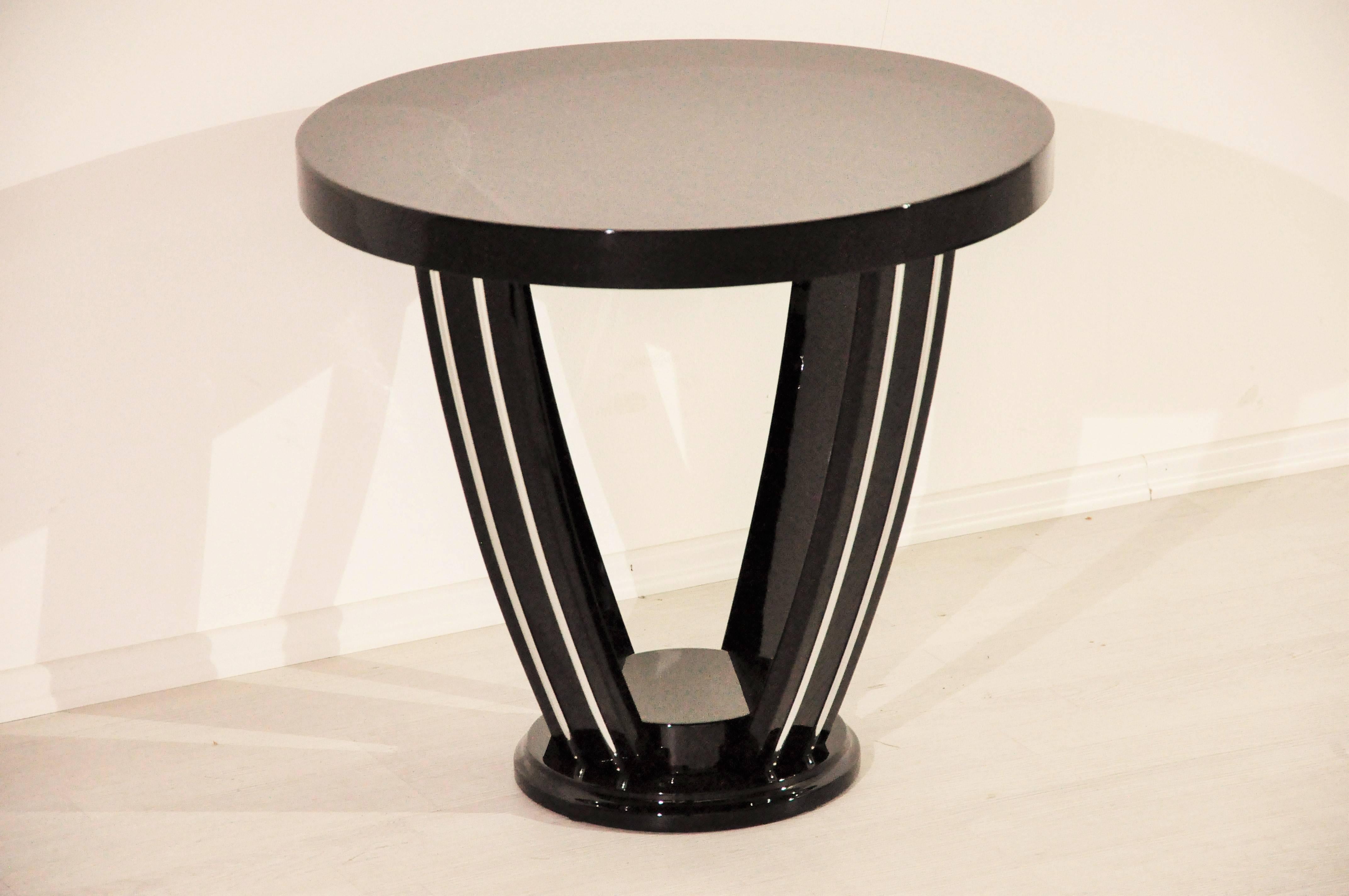 Beautiful Art Deco side table from the 1920s. Costly restored and lacquered with up to ten layers of pianolacquer in our manufactory. The great curved legs are additionally ornamented with metal fillets – a wonderful design element.

 Original