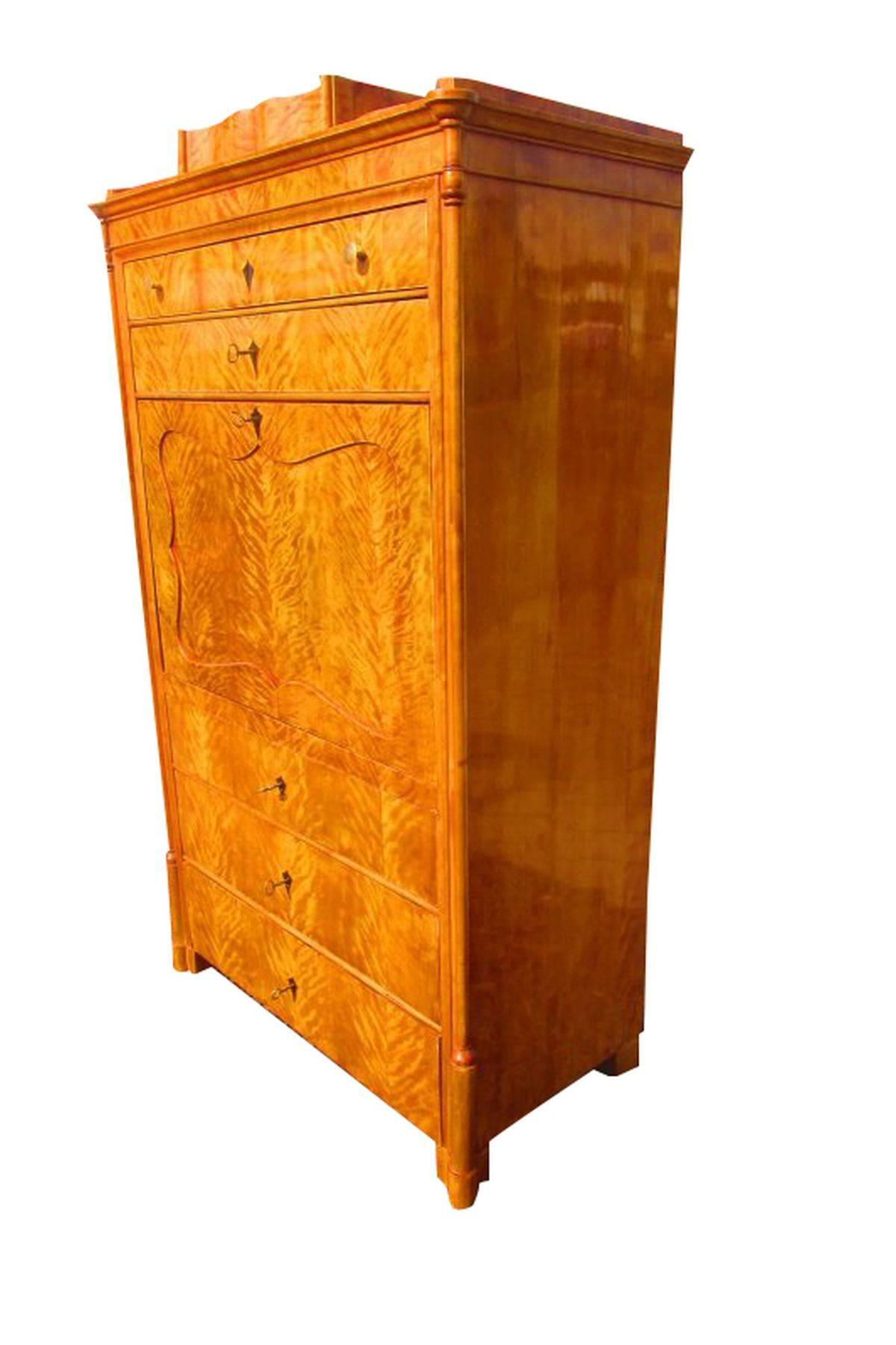 Biedermeier Secretary with a birch veneer. The wonderful grain is hand polished and adds a wonderful tone to the furniture. It has a great interior with 16 drawers and a writing flap which is hingedable. A typical Biedermeier secretary.

Birch