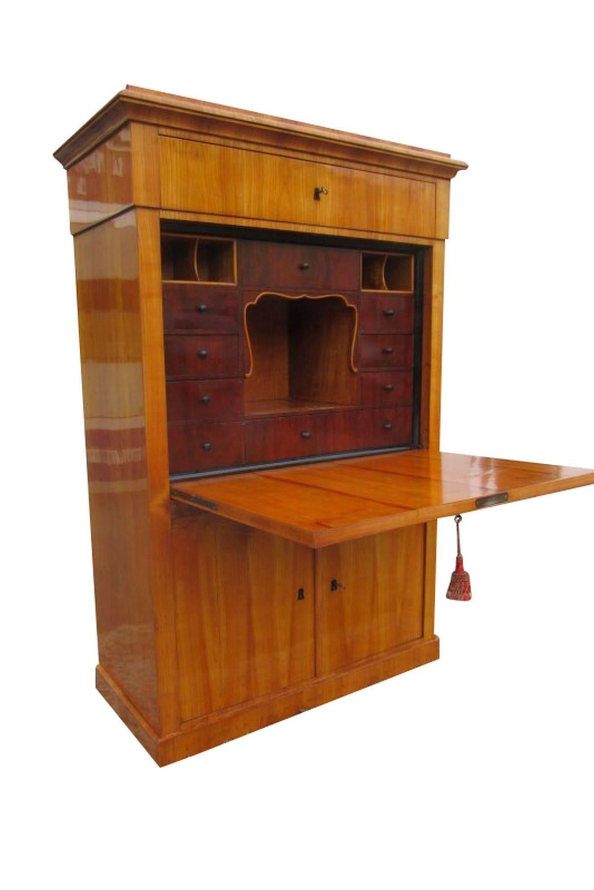 A great Secretary from the Biedermeier period. The piece offers a great storage room with many drawers. Unfolding the write flap reveals more drawers in a dark brown color. The ornaments inside mixed with the color play is a real sight. This