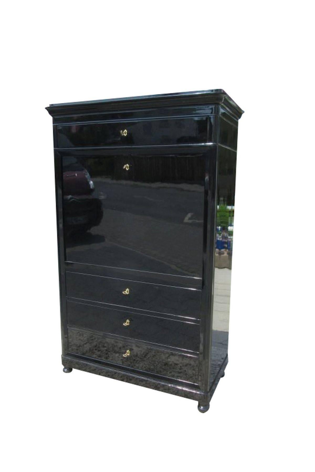 A black secretaire from the Biedermeier period. This unique looking piece is coated with a black lacquer. The cabinet is veneered with cherrywood and has seven drawers and a big free compartment. The secretaire has four additional drawers outside