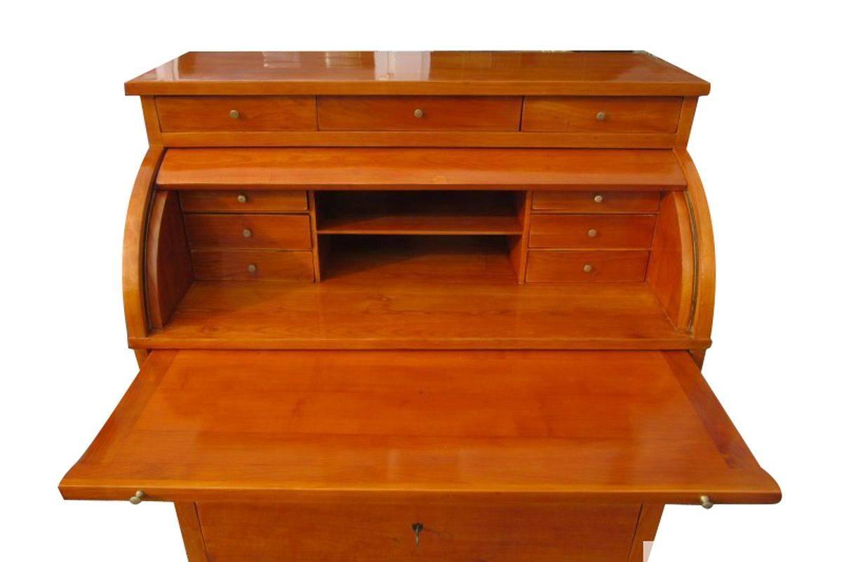 A 1820s Biedermeier commode veneered with cherrywood. The hand polished veneer gives the piece a beautiful color tone and overall look. It has twelve drawers and a two free compartments in the middle. Three locks in the original available with three