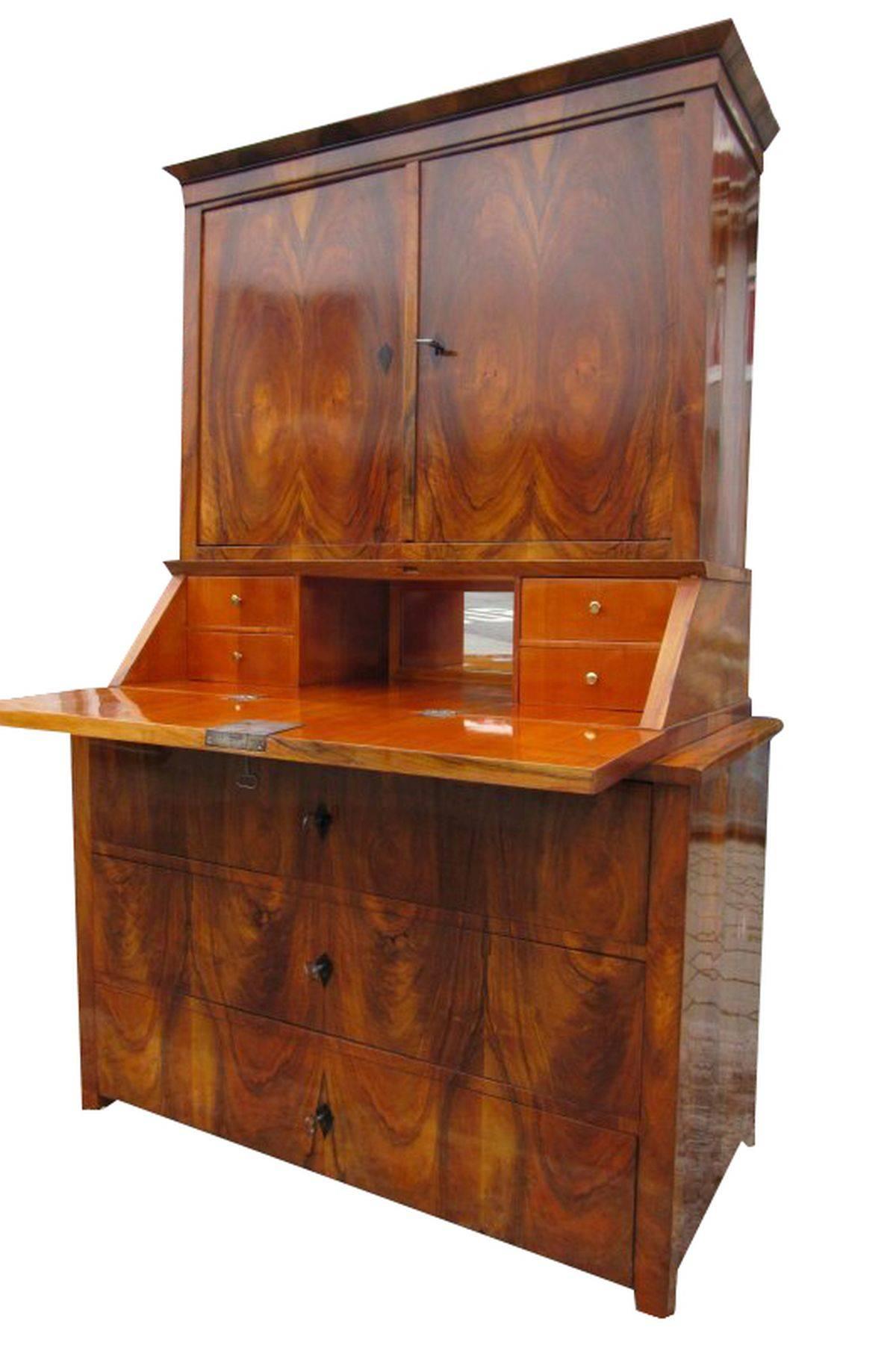 A great Biedermeier Secretaire made of softwood veneered with walnut wood. Beautiful grain and simple but elegant design. It has three big drawers and inside the piece 10 more drawers. It offers a wonderful color tone with its cherry tree veneer