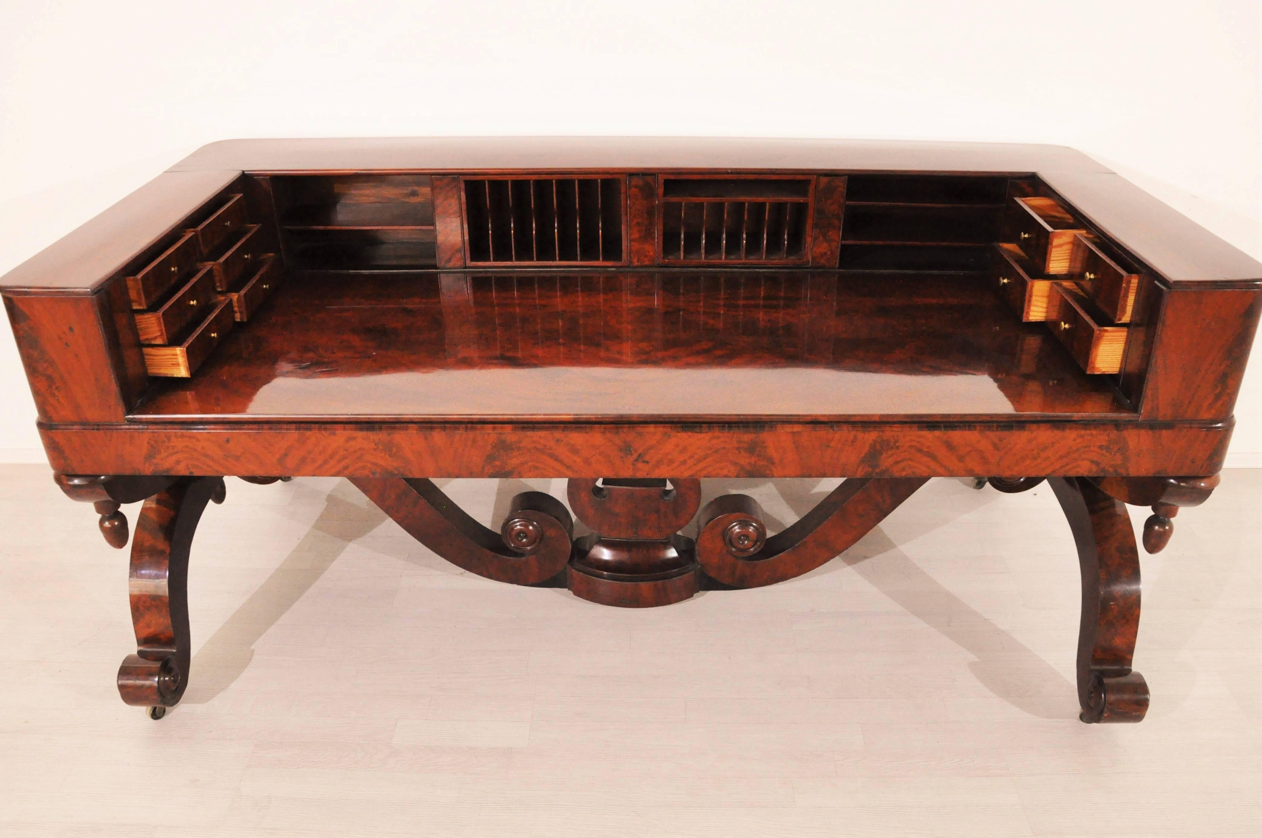Unique large 1830s Biedermeier mahogany desk from northern germany. It offers a pyramid mahogany veneer on the front and back and wonderful detailed and hand crafted feet. On the tabletop you will find a lot of small drawers with original brass
