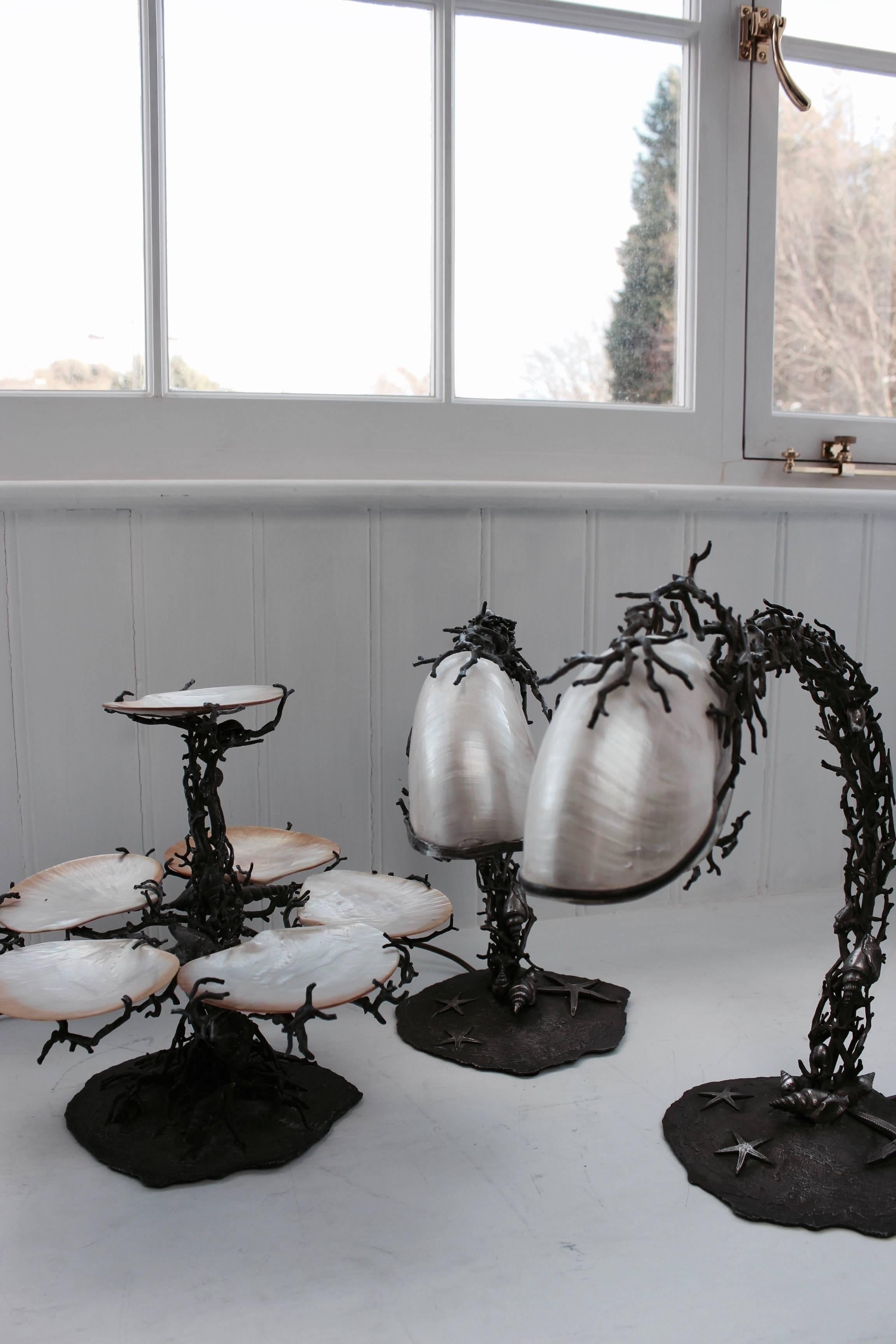 The silvered brass table lamps and centre piece mounted with seashells, starfish and nautilus pearl shell shades, the lamps wired for electricity.