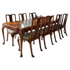 Ein ausziehbarer Esstisch im Stil von George I. in Nussbaumfurnier und zwölf Stühle