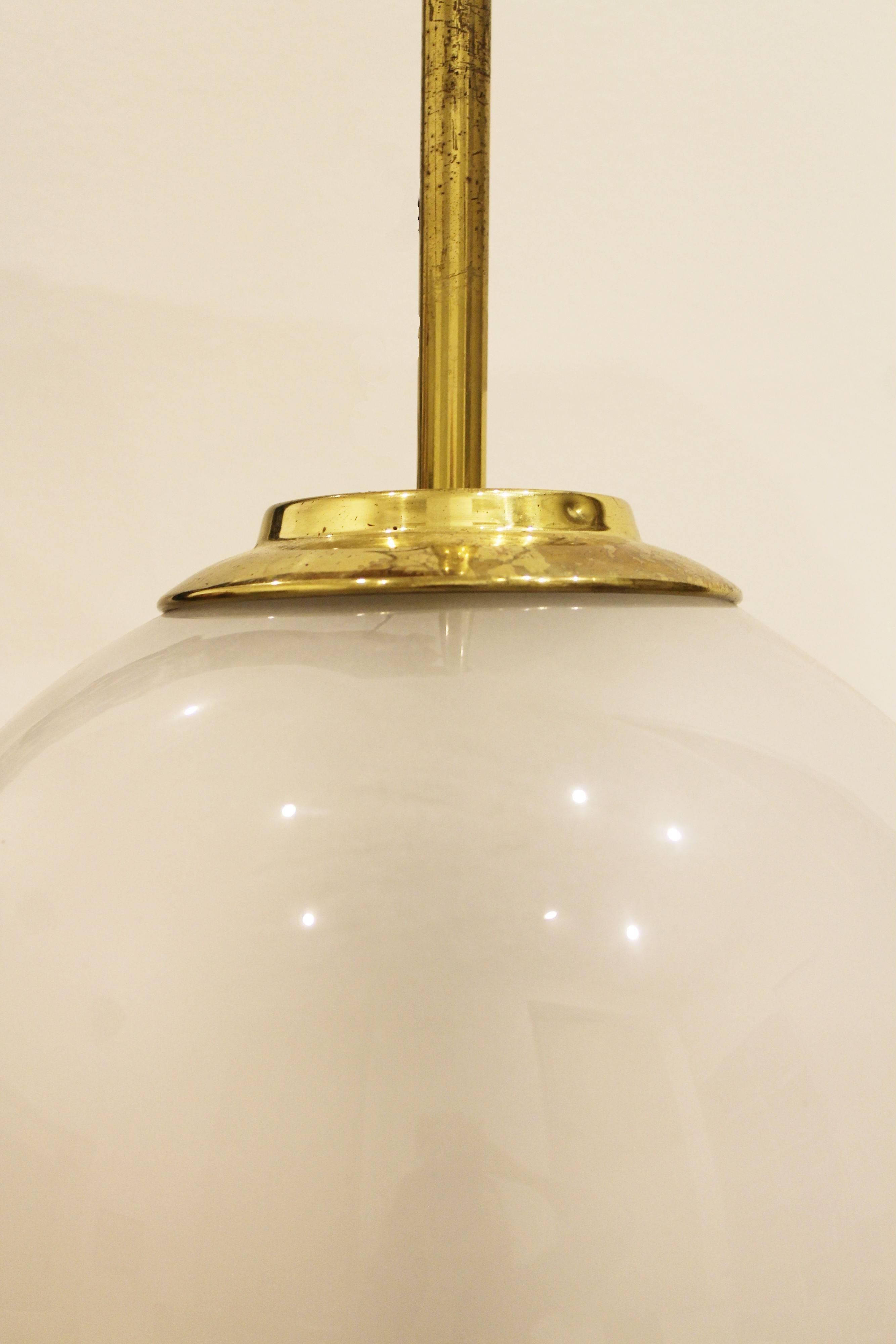 Pair of wall sconces called Lp11 'Pallone, designed in 1958, by Luigi Caccia Dominioni, Manufactured by Azucena, Milan.
Opaline glass globe on mobile gilt brass tube, fixated on rectangular wall plate (25 x 6 1/2 cm). 
External black cable.
  