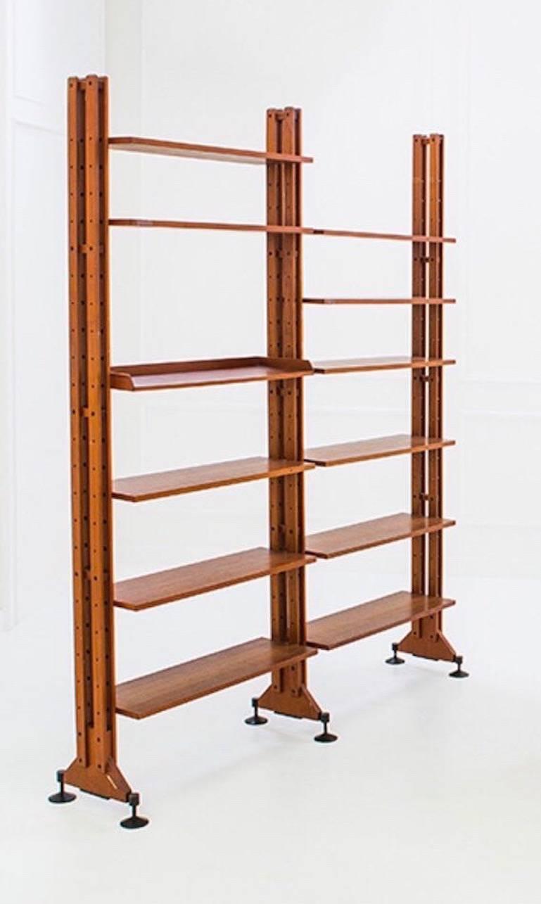 Important bookcase with two mounting parts. Extendible and adjustable wooden legs,terminating with iron feet; 12 étagères are included in the bookcase structure.