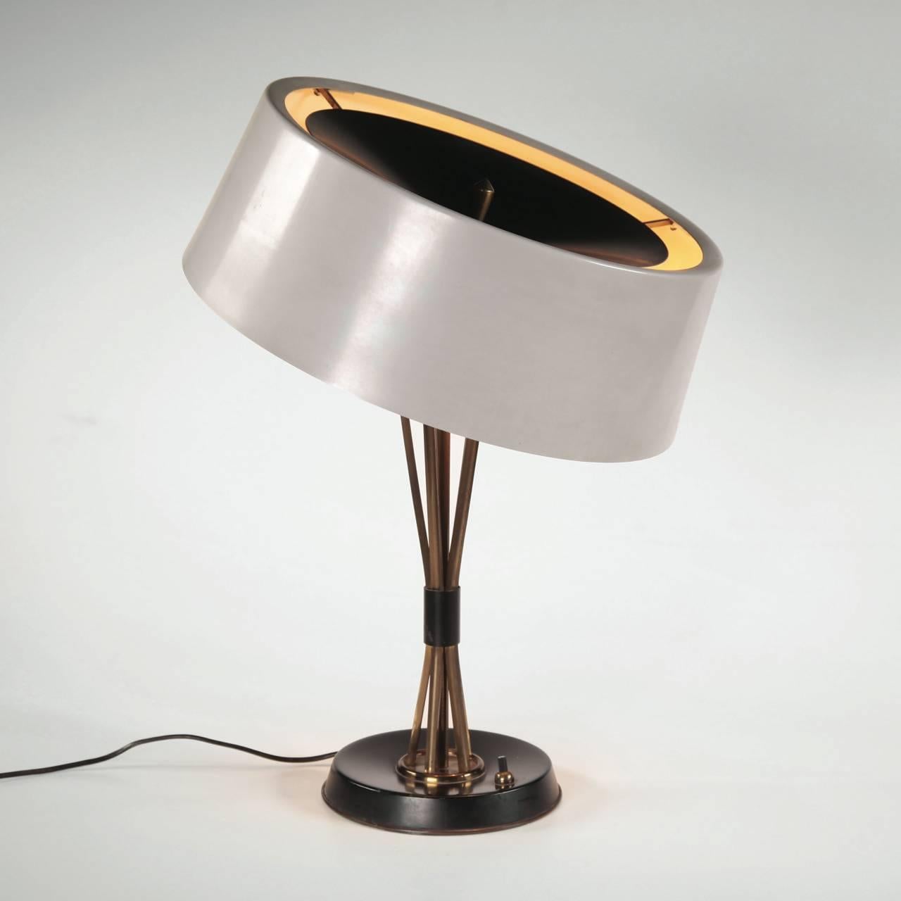 Elegant table lamp in brass with lampshade in varnished metal designed by Oscar Torlasco and produced by Lumi, Italia, circa 1950.