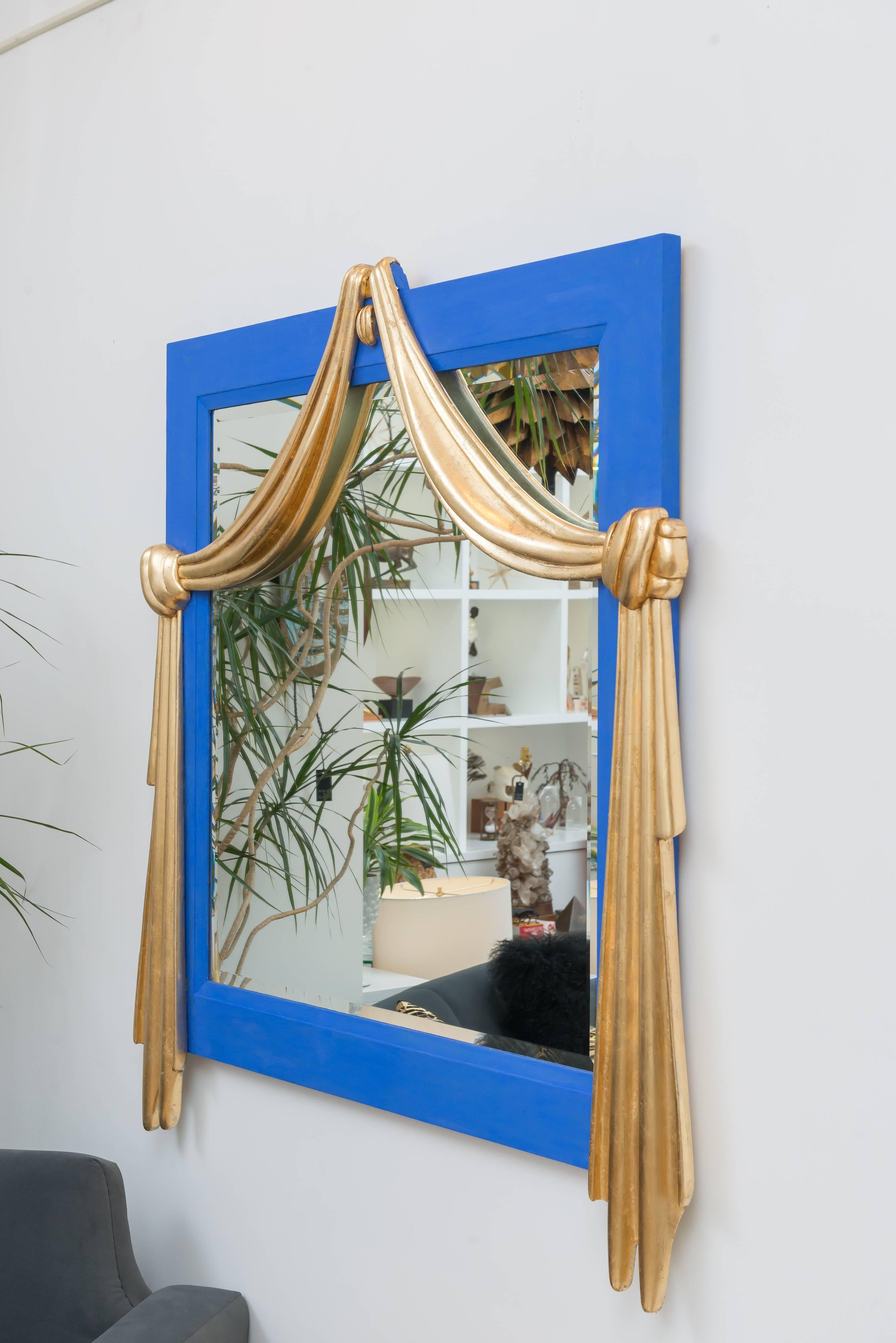 Large-scale mirror p that has been painted in a French flat blue paint with gilt draped detail.