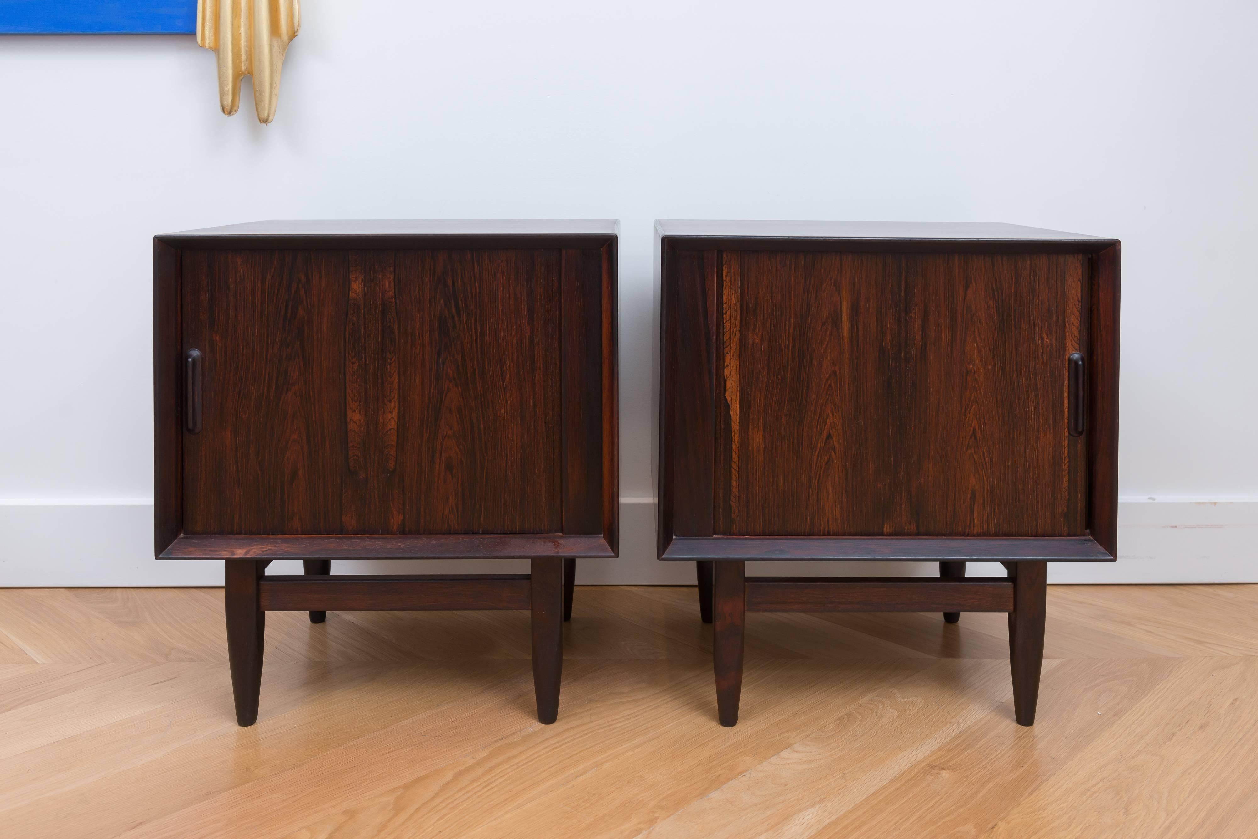 Pair of rosewood nightstands by Arne Wahl Iversen for Falster, circa 1958. Has a front tambour with an interior drawer, with an open storage space and an adjustable shelf. Solid construction also finished on the back.