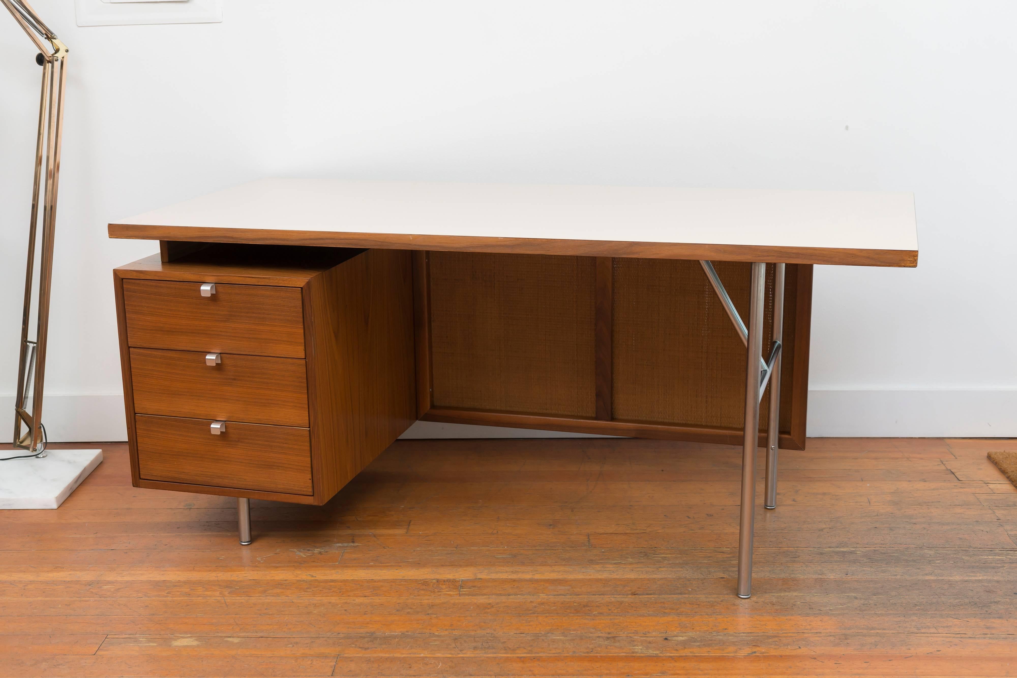 Walnut George Nelson for Herman Miller desk with a laminate top and woven grass privacy panel.
