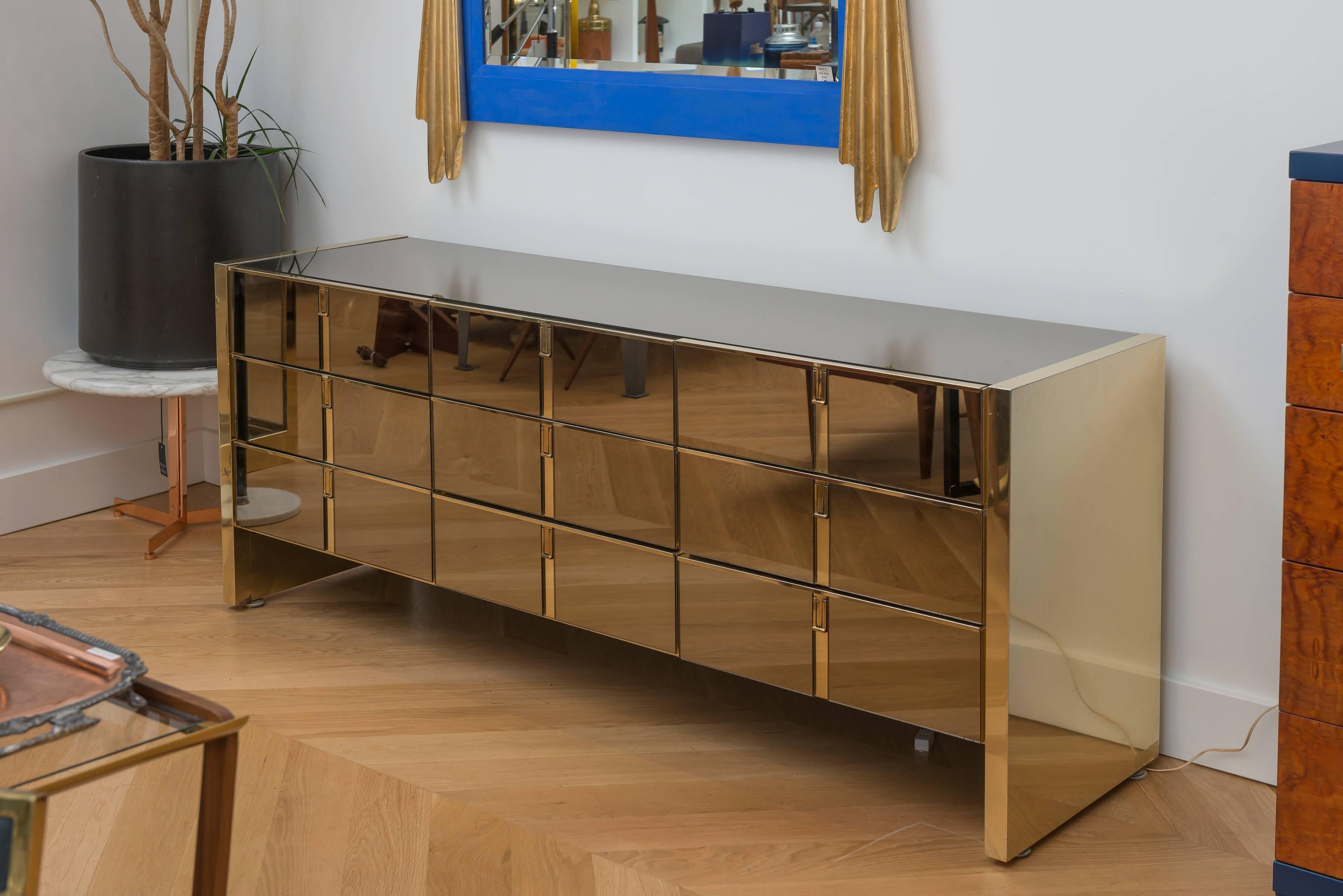 Unique mirror and brass detailed dresser by Ello Furniture makers. The beautiful mirror is a stunning example of Mid-Century Modern at its most glamorous. Nine drawers.