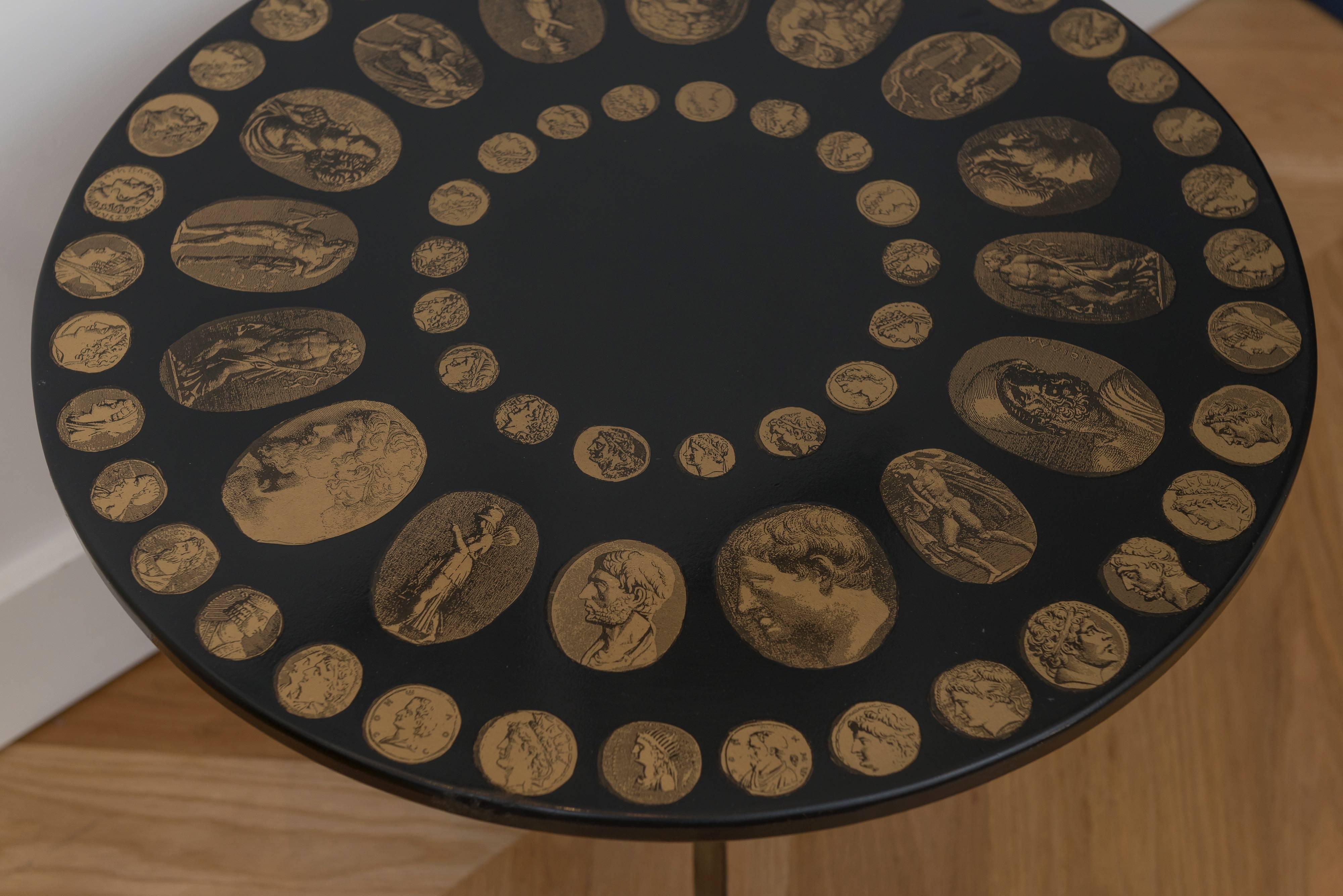 Fornasetti black and gold Italian coin table.