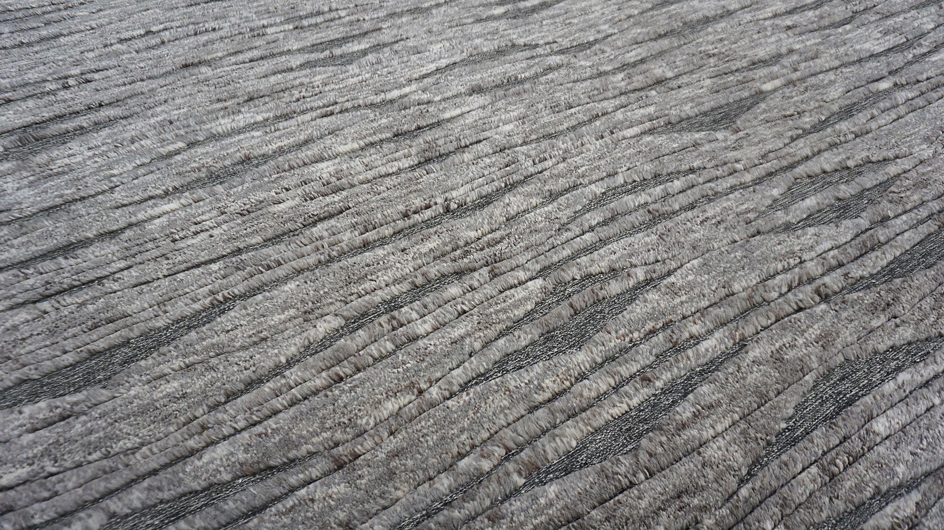 Dieser exquisite, handgeknüpfte Wollteppich fängt mit seinem fließenden Wellendesign die subtile, organische Schönheit der Natur ein. Dieses von Meisterhandwerkern sorgfältig gefertigte Stück ist ein Fest der Textur und Form und zeigt die