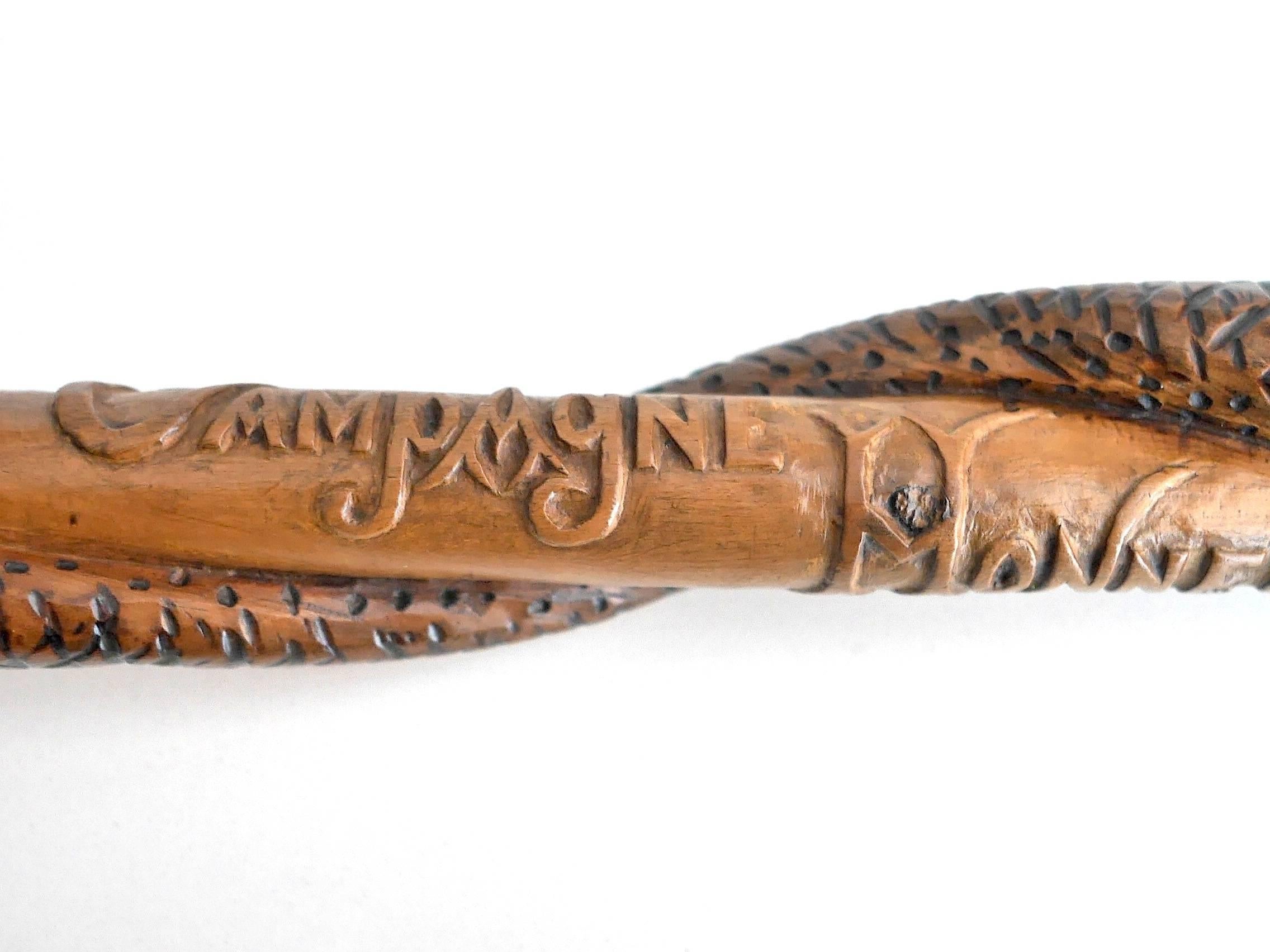 Pear tree cane, featuring on the pommel a soldier's head and an eagle separated in the middle by a skull. The stick is decorated with a snake. Various sentences celebrating the allies are engraved on the sides. Multiples dates 1914-1918 can be seen