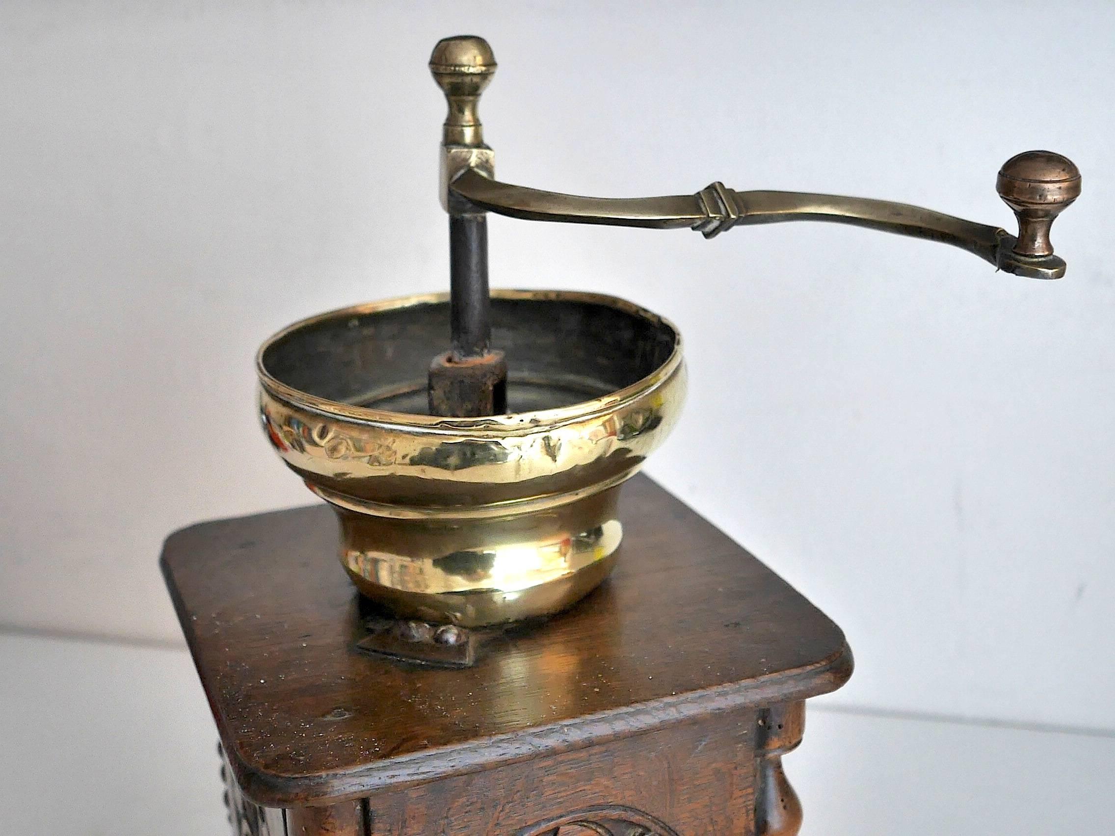 Oak and brass coffee grinder, from Belgium, decorated on four sides by rosaces.
 
