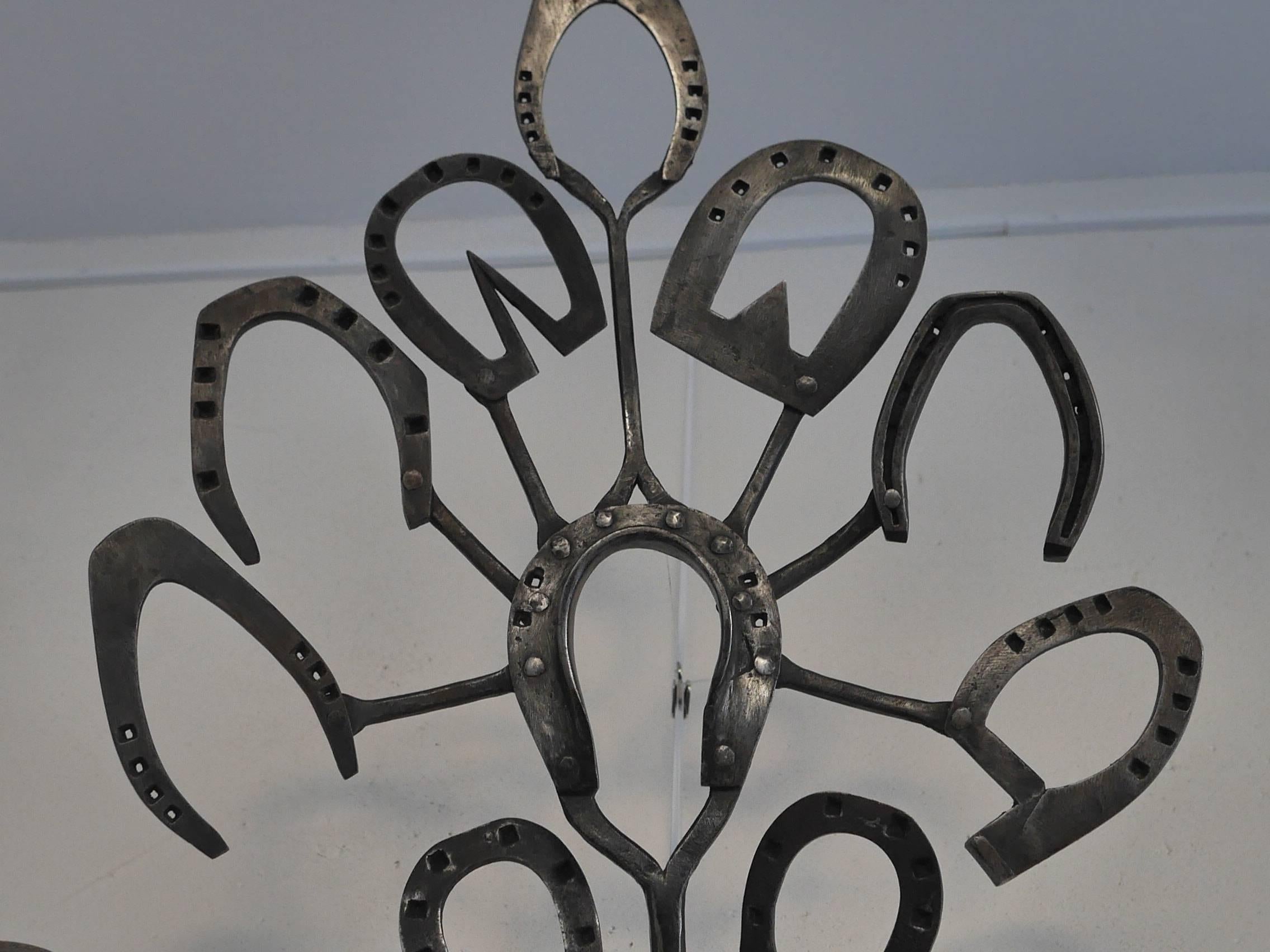 This sign figures a traditional bouquet of St. Eloi, made in honor of the patron of metal craftsmen. Its purpose is to show the different types of horseshoes that could be executed by the blacksmith.  A giant central iron is surrounded by twenty two