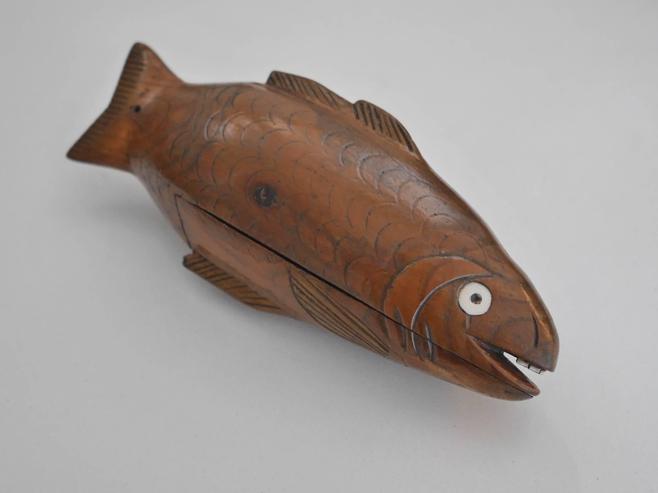 Wooden snuffbox shaped as a fish with eyes and tooth sculpted in bone. It must have belonged to a sailor.
This is a typical Folk Art piece of work. Inhaling snuff, or snuffing, as it is also called, was first witnessed by a European missionary in
