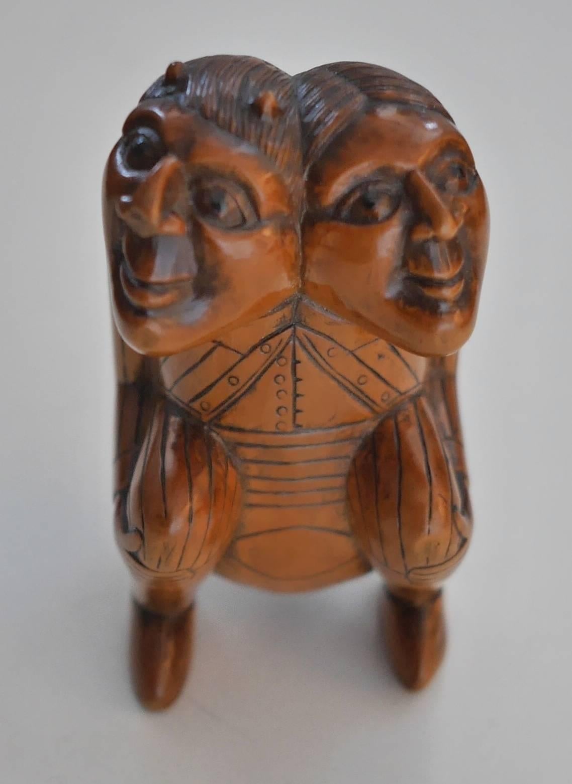 Little boxwood snuffbox featuring a double faced man, or twins, one of them wearing horns, representing the duality of human beings.
This is a typical Folk Art piece of work. Inhaling snuff, or snuffing, as it is also called, was first witnessed by