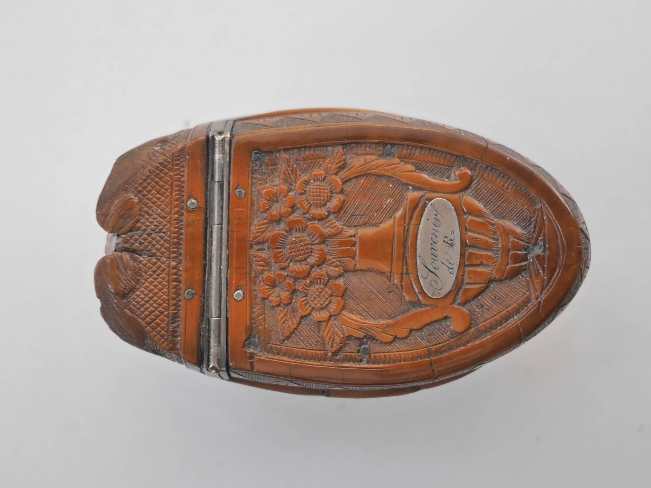 Beautiful Tagua nut carved snuffbox featuring a whale's head with sulphur eyes. 
The lid is decorated by a flowered vase topped by the inscription 