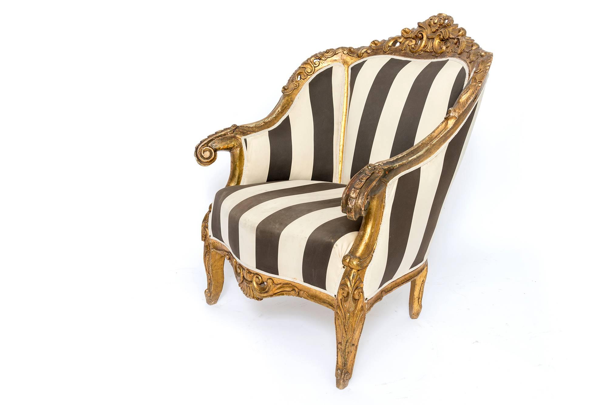 From France, 1890. Two over-sized and extremely caressing fauteuils with gilt wooden ornate work. An incredible accent pair for your grand salon or living room, library and more.