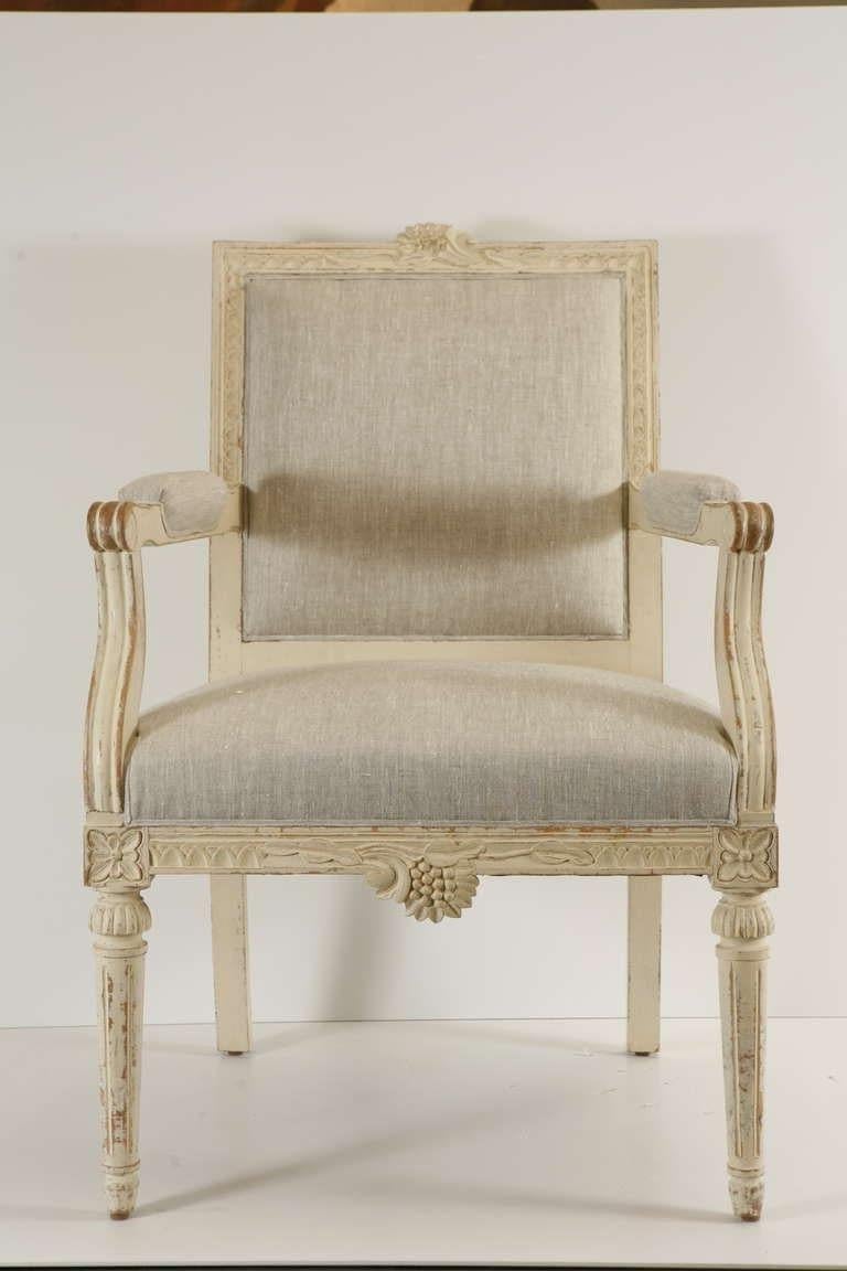 A pair of white painted Gustavian style fauteuils covered in new light natural linen. Great distressing and patina.