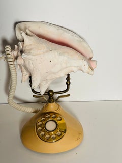 Sculpture représentant un téléphone Totary ancien ornée d'une grande conque naturelle