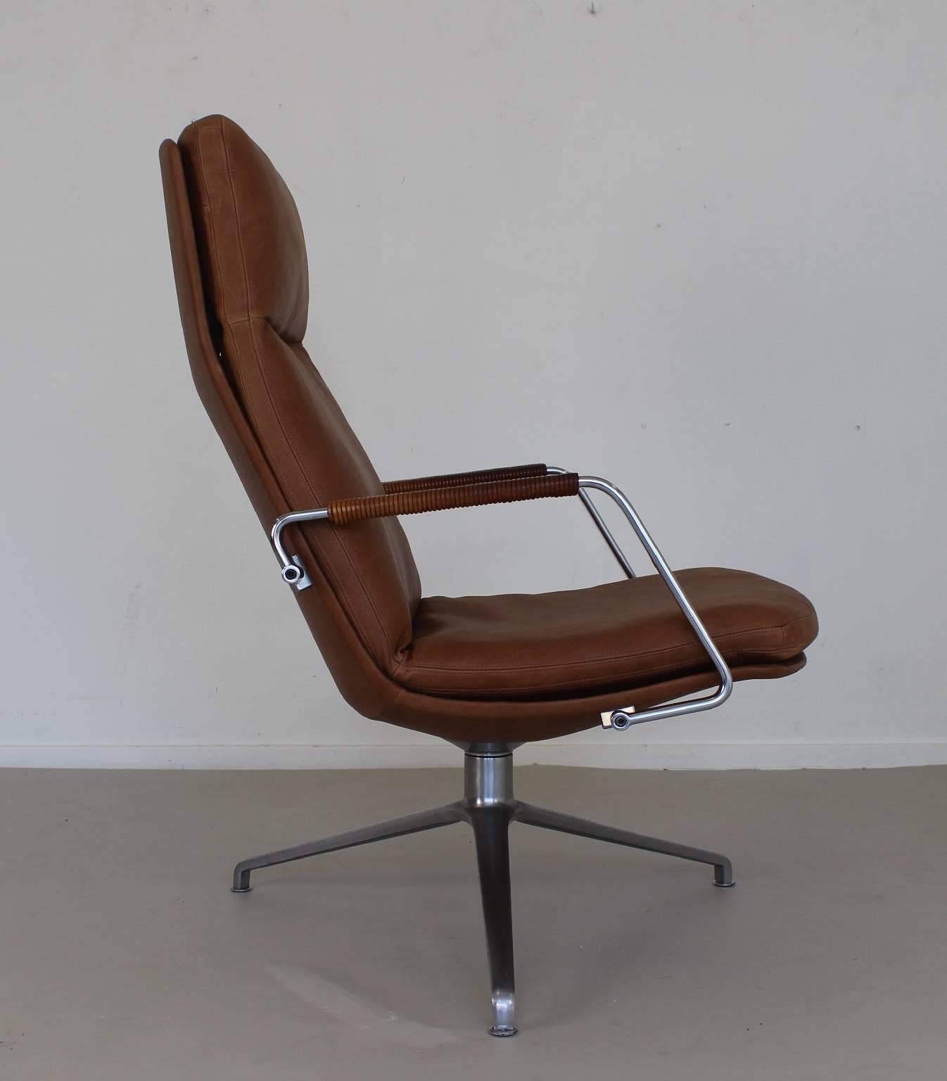 Superb design office chair.
Tripod brushed steel base.
Revolving tub.
Re-upholstered in best brown leather.
Leather wrapped steel armrests.