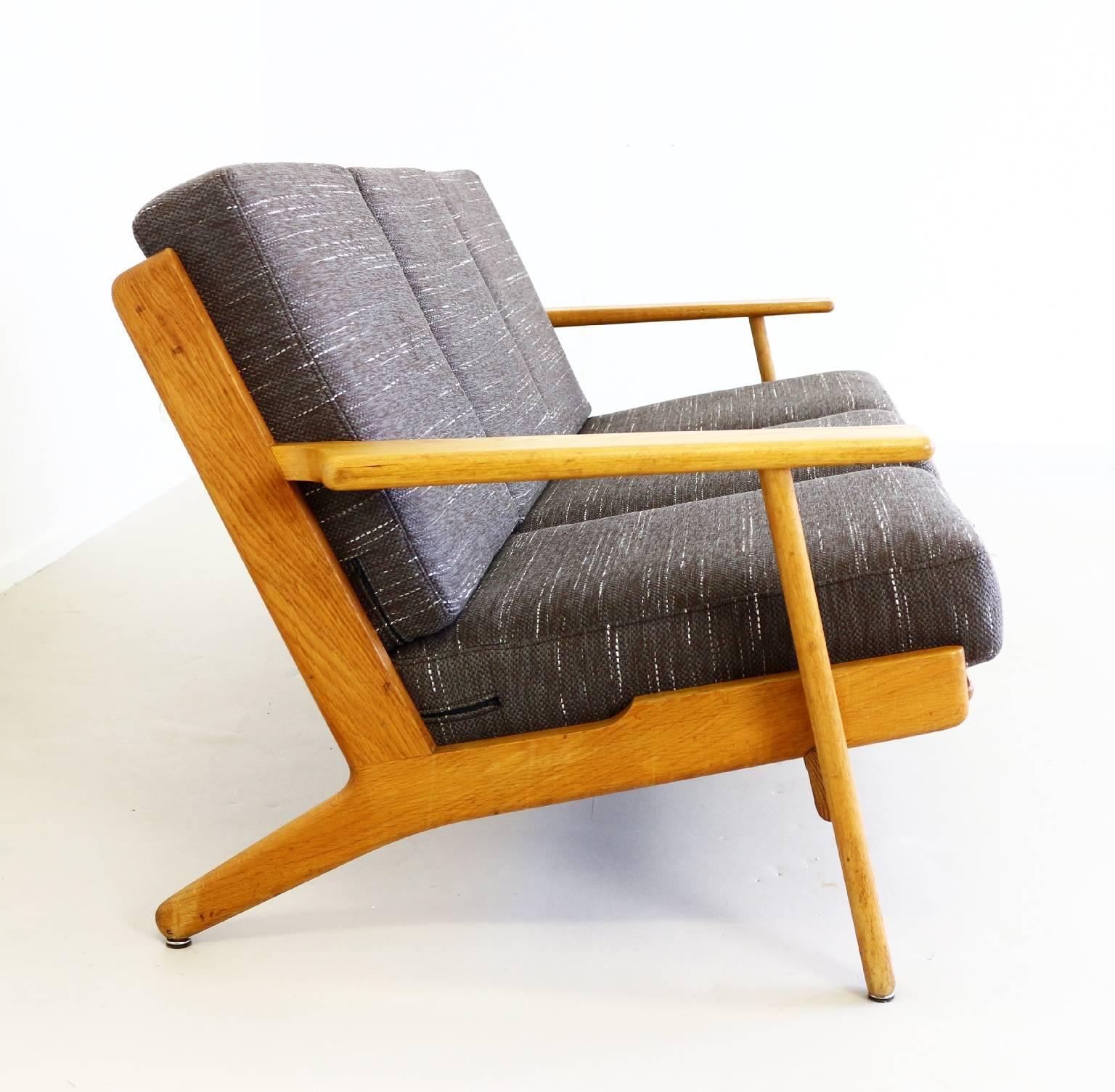 Danish design Hans Wegner sofa
in solid oak.
Reupholstered in beautiful brown fabric.
Original spring cushions.
Model GE 290 and made by GETAMA, Denmark.