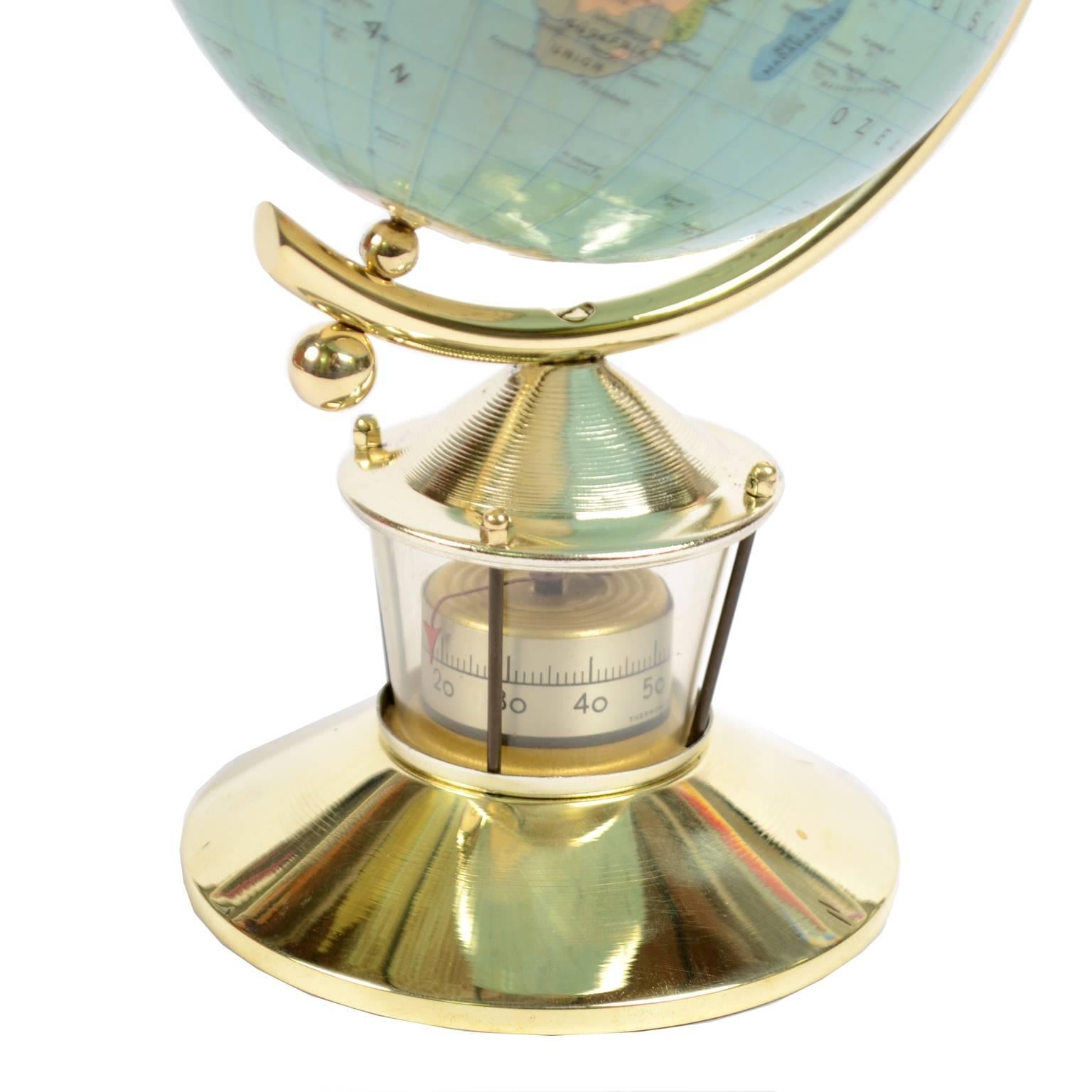 Small Flemmings Verlag Hamburg globe papier mâché covered with paper, brass base with meridian circle and thermometer, 1950s. Very good condition. Measures: Height cm 23, sphere diameter cm 12.