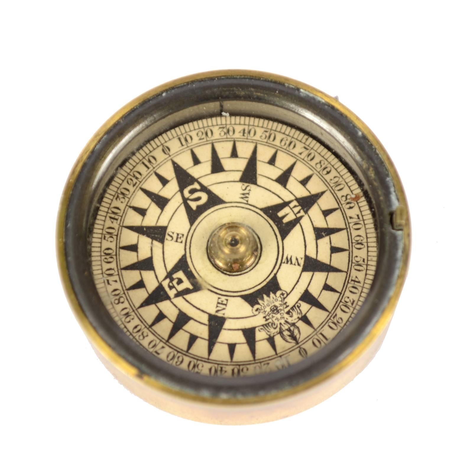 Small dry pocket nautical compass placed in its original box made of turned brass, complete with brass cover and closed by a protective glass. From the Victorian era of the second half of the 19th century. Eight-wind compass card printed on paper by