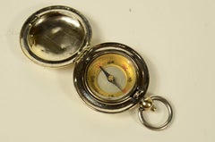 Small travel compass made of chrome-plated brass, shaped like a pocket watch