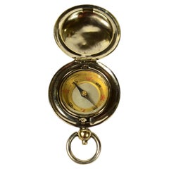 Small travel compass made of chrome-plated brass, shaped like a pocket watch