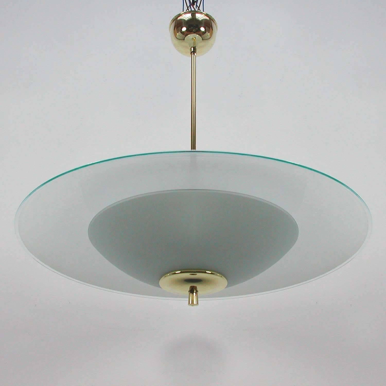 Awesome, large 1950s Italian UFO chandelier in the manner of Fontana Arte or Pietro Chiesa.

The chandelier has been rewired and the brass pieces polished. It requires two E27 screw on bulbs and works on 220 V as well as 110 V.