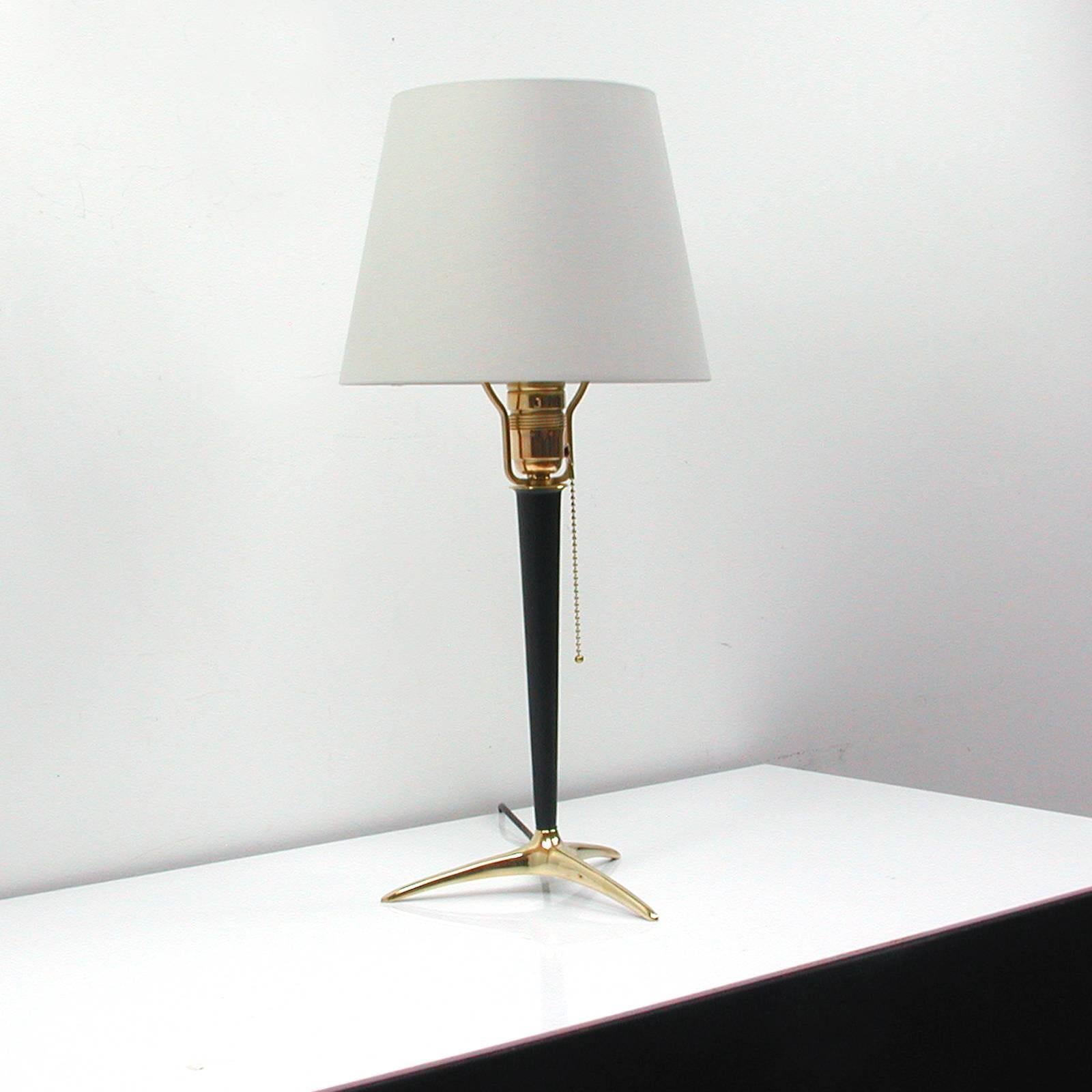 Tripod brass and black lacquered metal table lamp, made in Austria in the 1950s in the manner of J.T. Kalmar.
The lamp shade is cream colored.