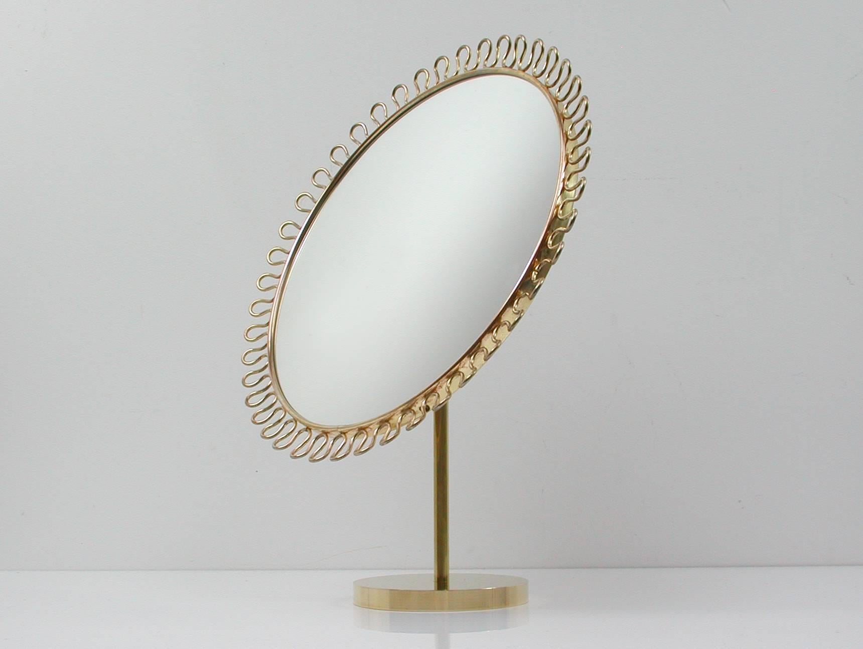 Beautiful sculptural brass-plated loop table mirror with adjustable mirror and wooden rear on bronze base in the manner of Josef Frank for Svenskt Tenn, Sweden, 1950s.
In excellent condition both brass and mirror with nice warm patina.
